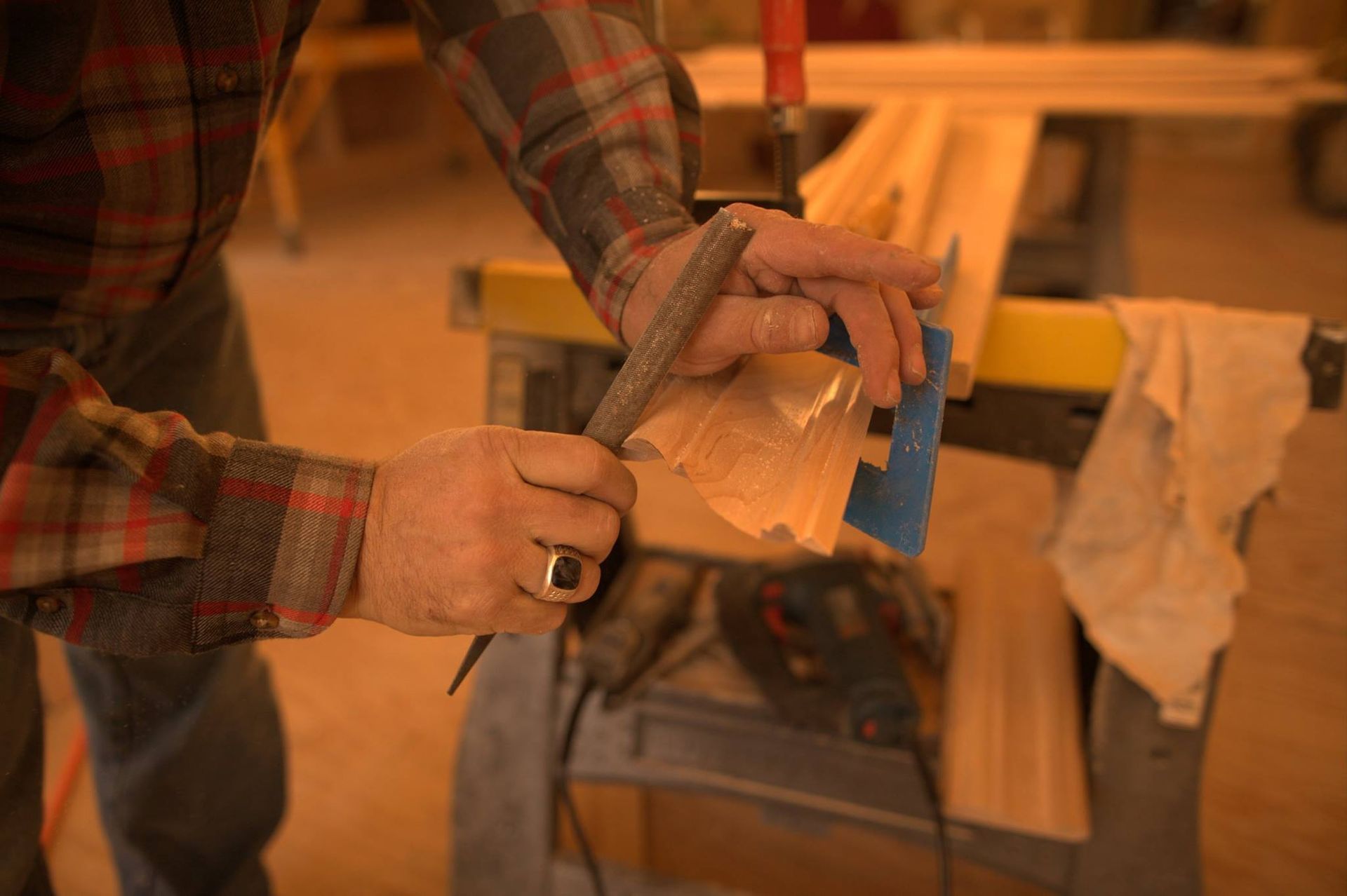 A man is cutting a piece of wood with a saw.