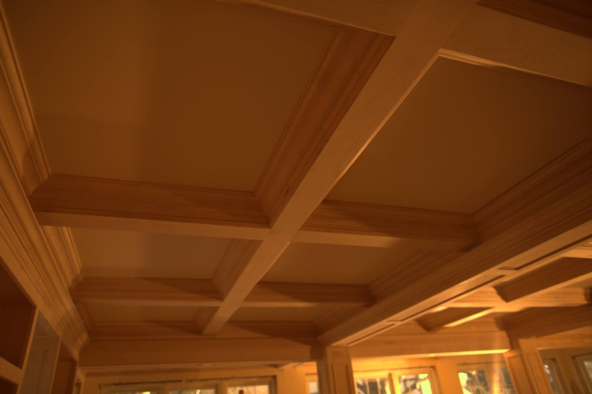 A ceiling with wooden beams in a room with a lot of windows.