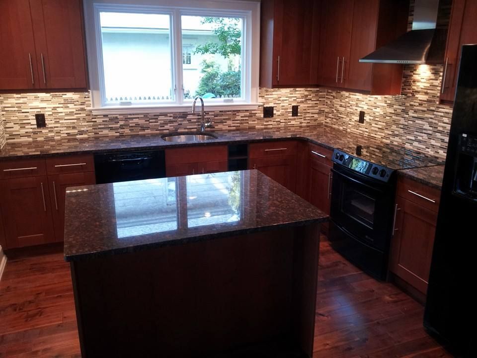 A kitchen with wooden cabinets and granite counter tops