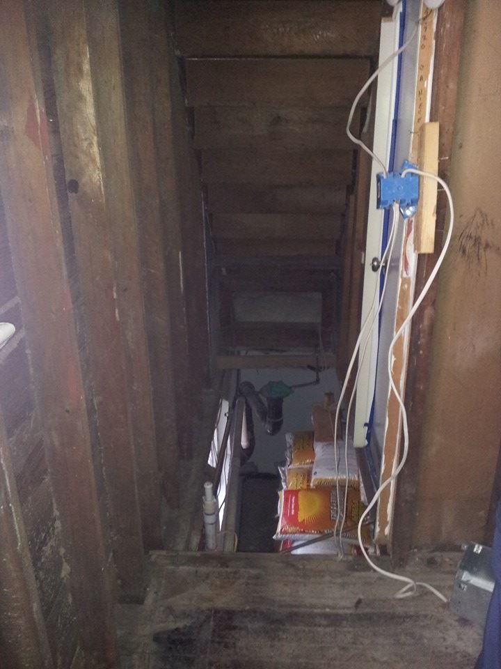 A dark room with a staircase leading up to it