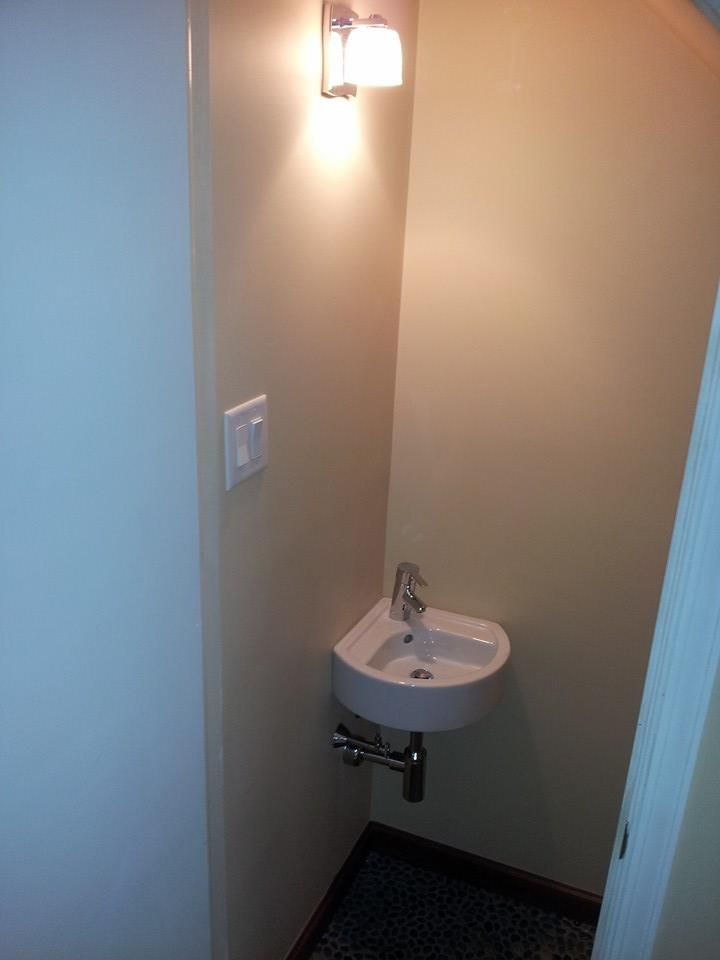A bathroom with a sink and a light on the wall
