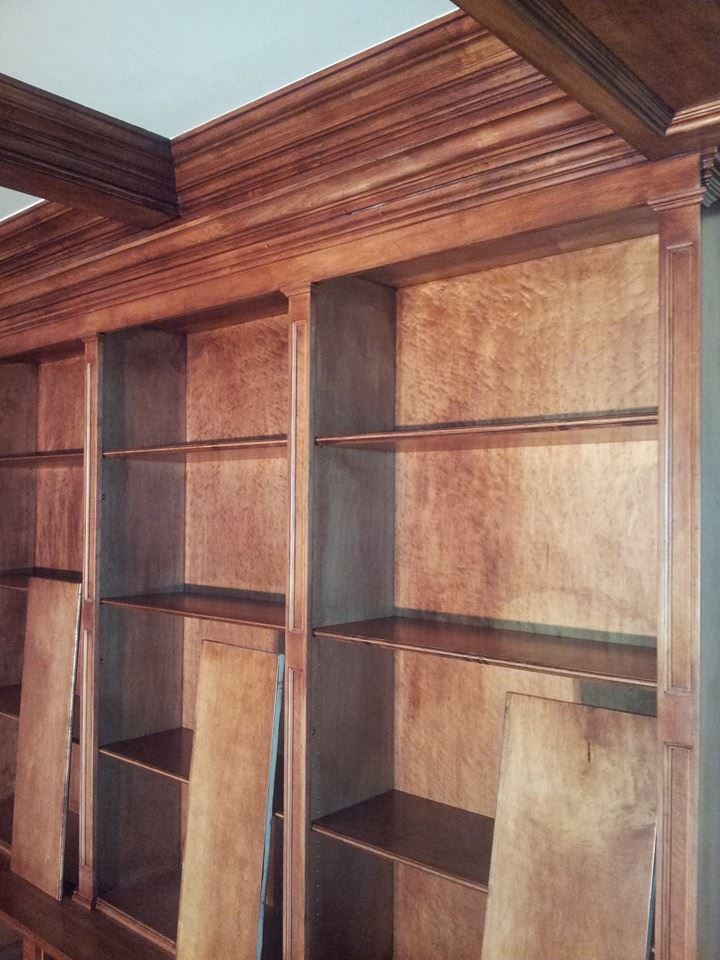 A wooden bookcase with lots of shelves in a room