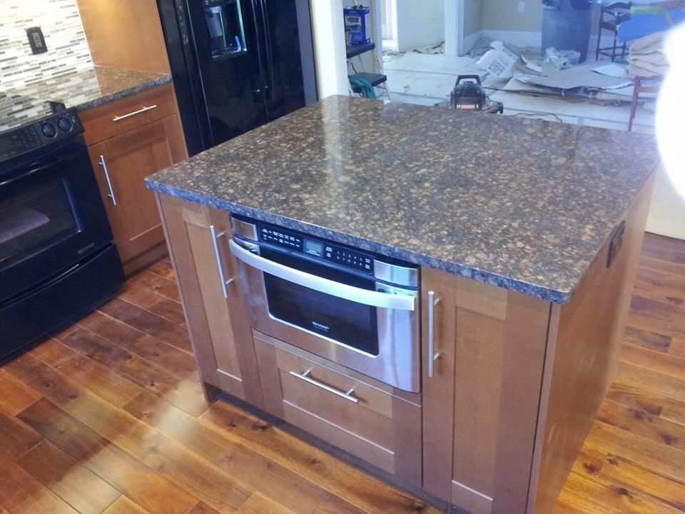 A kitchen island with a microwave oven on top of it