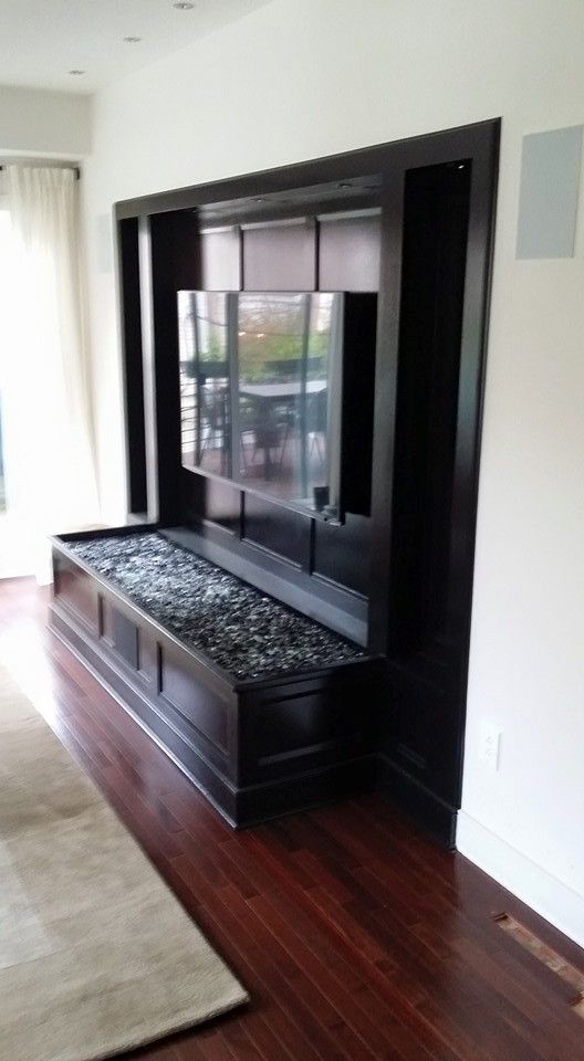 A living room with a flat screen tv mounted to the wall.