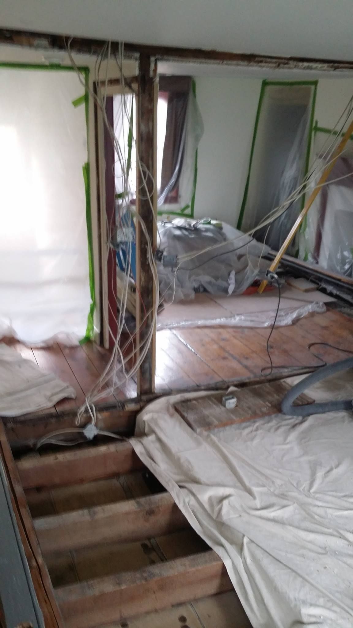 A room with a wooden floor and a ladder in it.