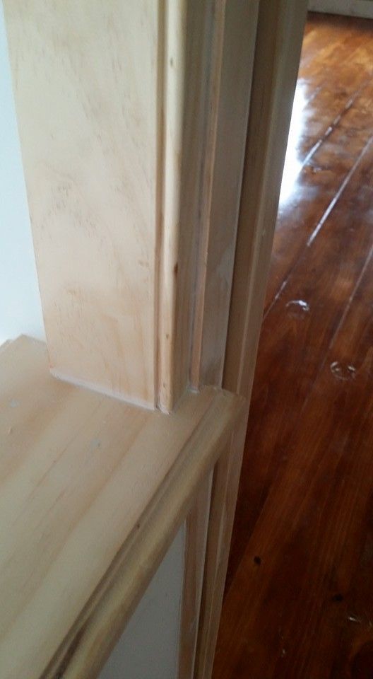 A close up of a wooden door with a wooden floor in a room.