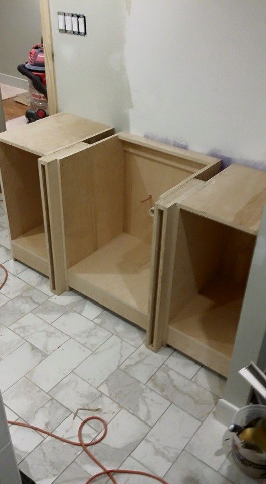 A couple of wooden cabinets sitting on top of a tiled floor.