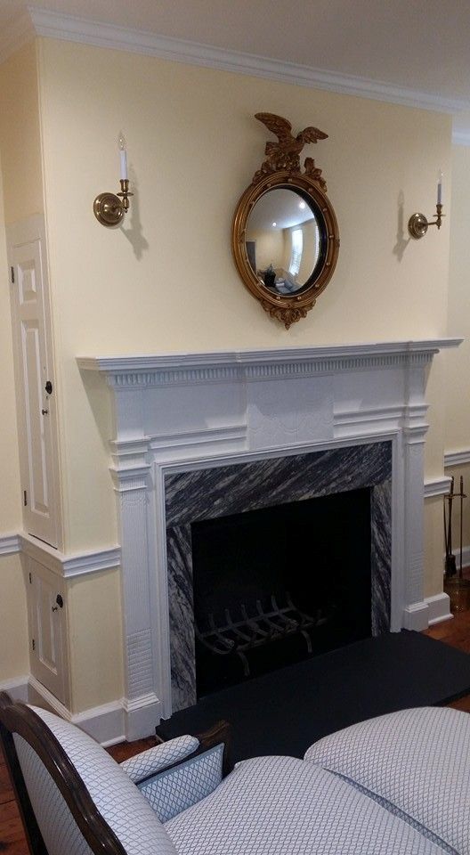 A living room with a fireplace , couch , and mirror.