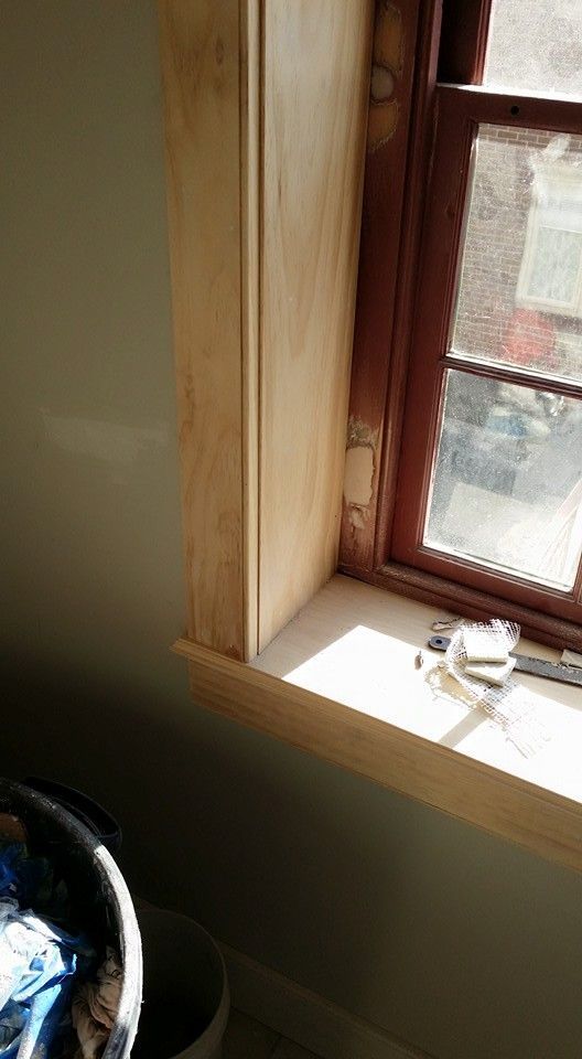 A window sill with a measuring tape on it in a room.