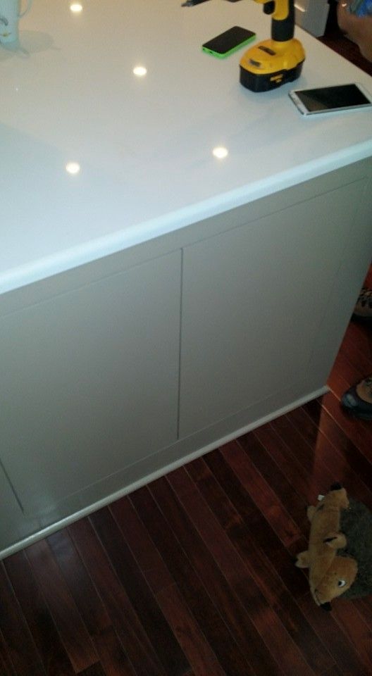 A yellow drill is sitting on top of a white counter.