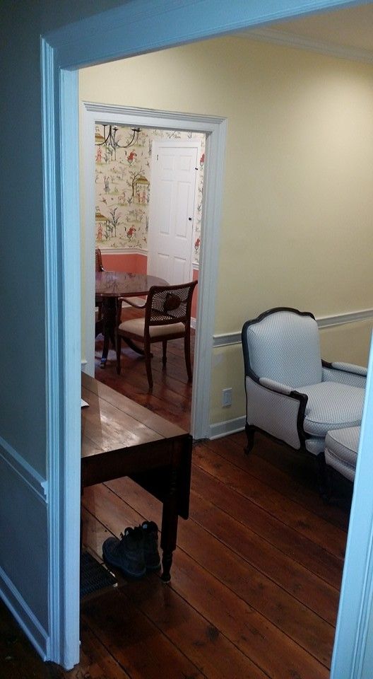 A living room with hardwood floors and a table and chairs.