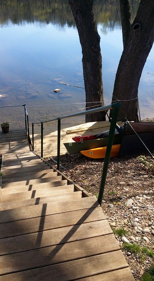 A wooden staircase leading to a lake with kayaks on the shore.