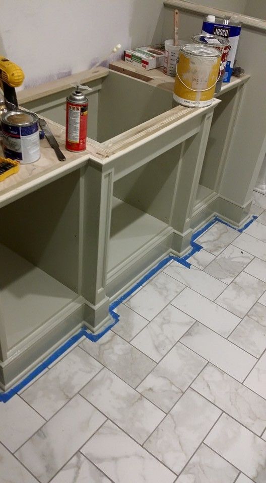 A kitchen is being remodeled with a herringbone tile floor.