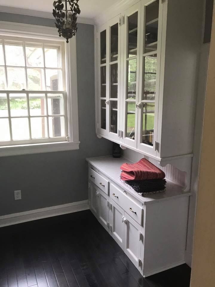 A kitchen with white cabinets and a window.