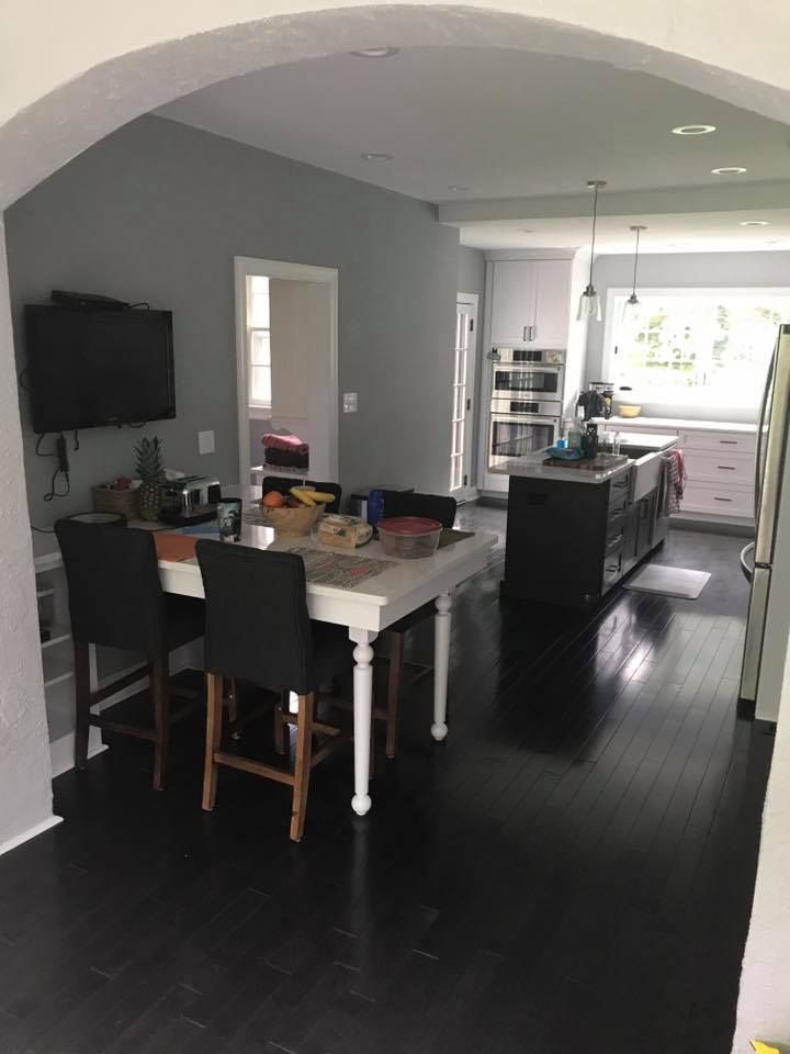 A kitchen with a table and chairs and a flat screen tv.
