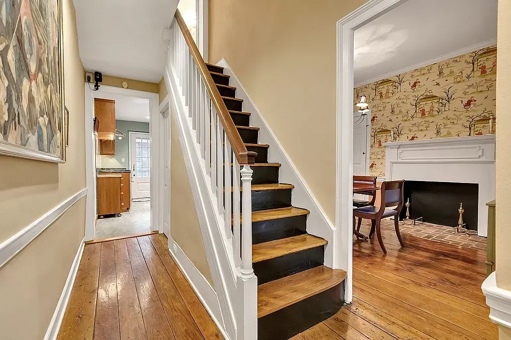 A hallway with stairs and a fireplace in a house