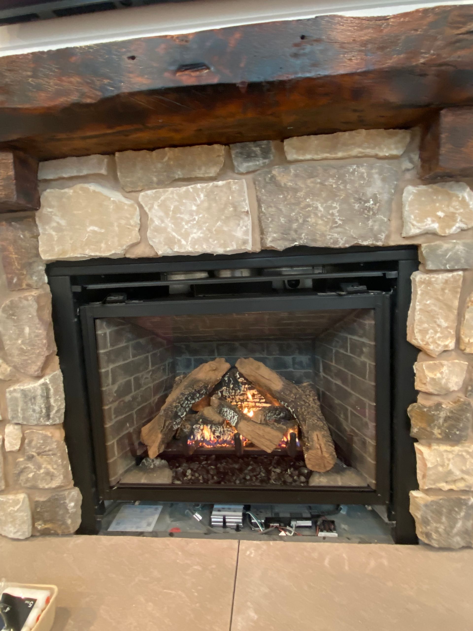 There is a fireplace with a lot of wood in it.