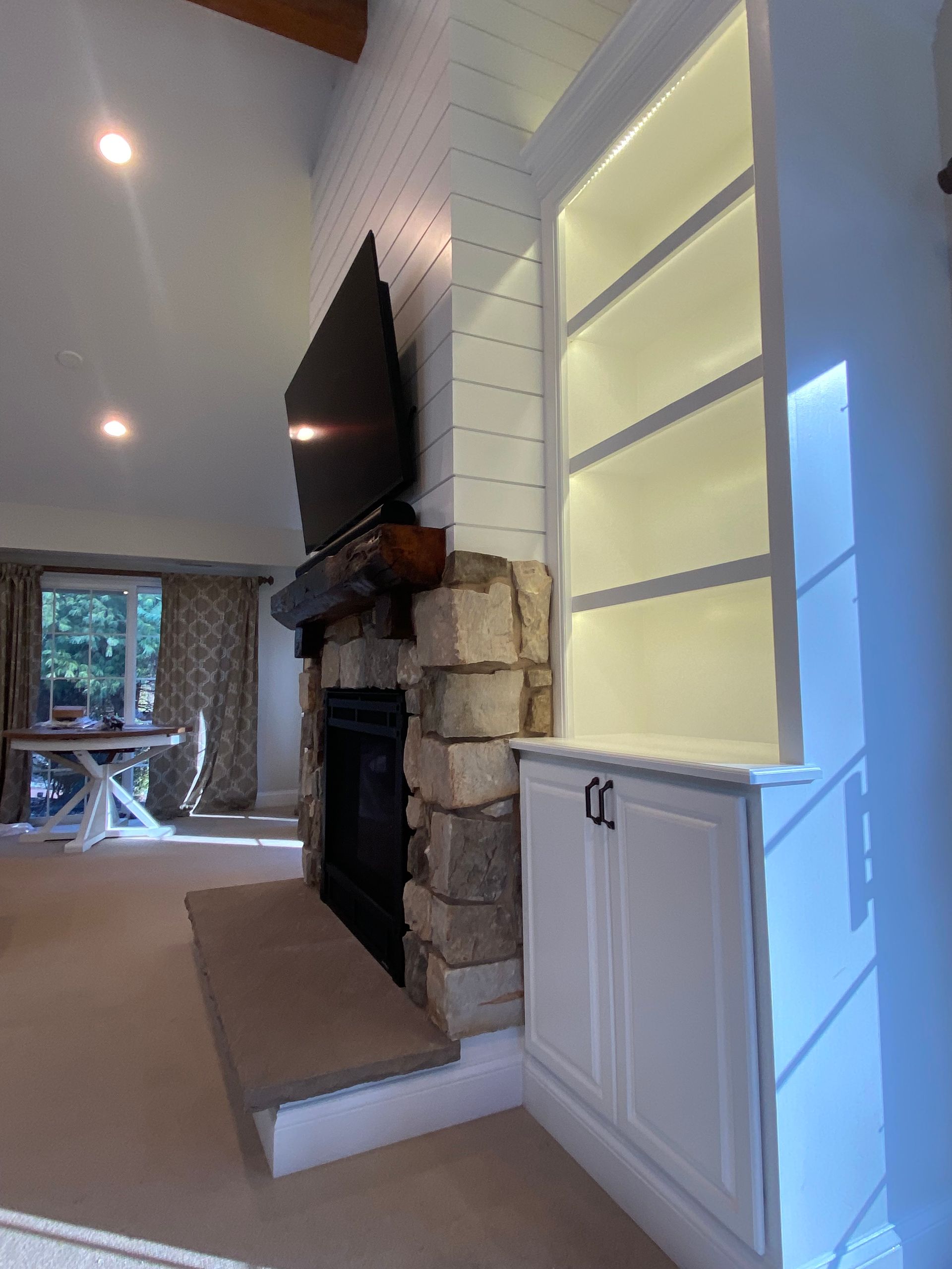 A living room with a fireplace and a flat screen tv