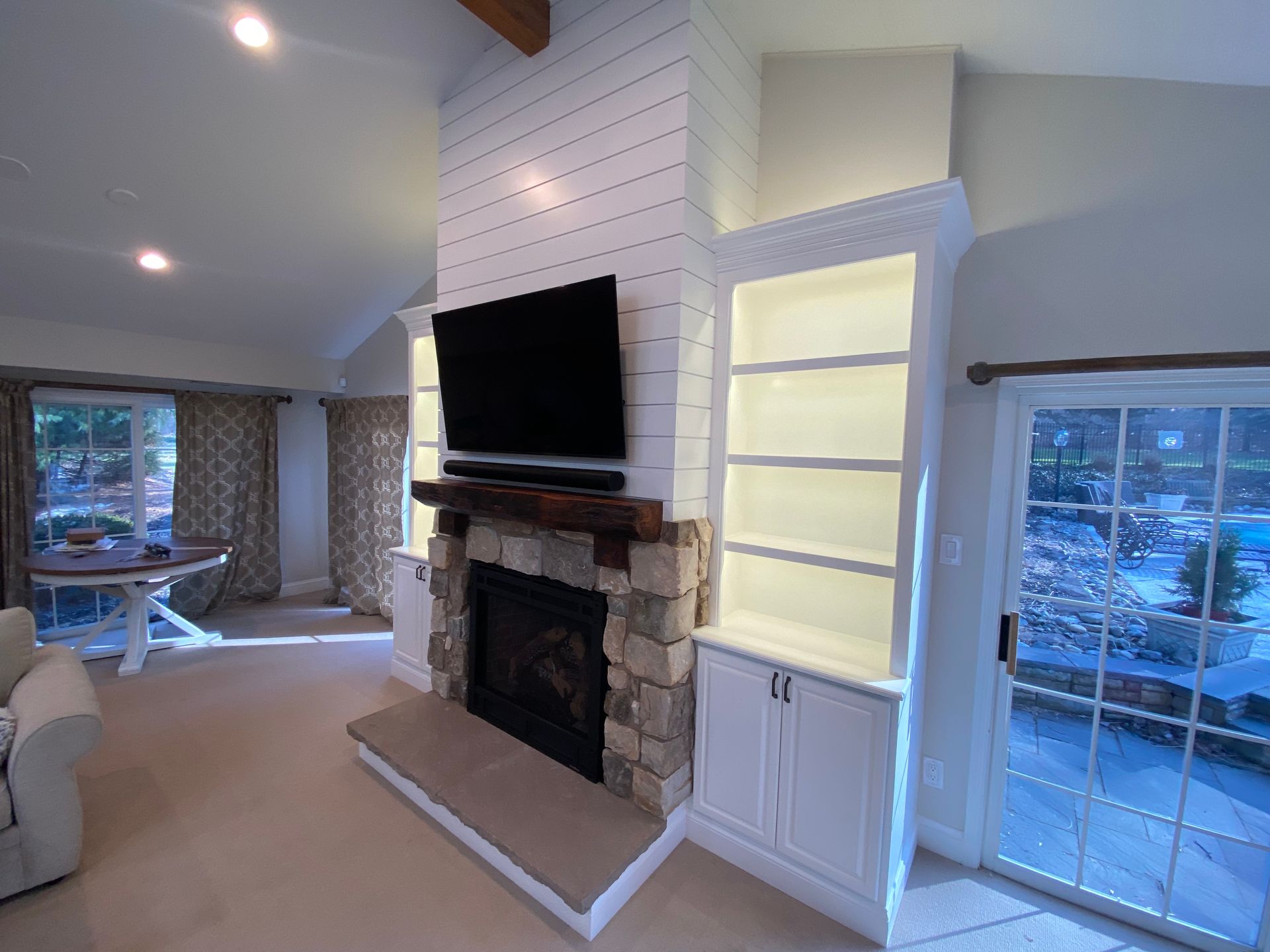 A living room with a fireplace and a flat screen tv on the wall.