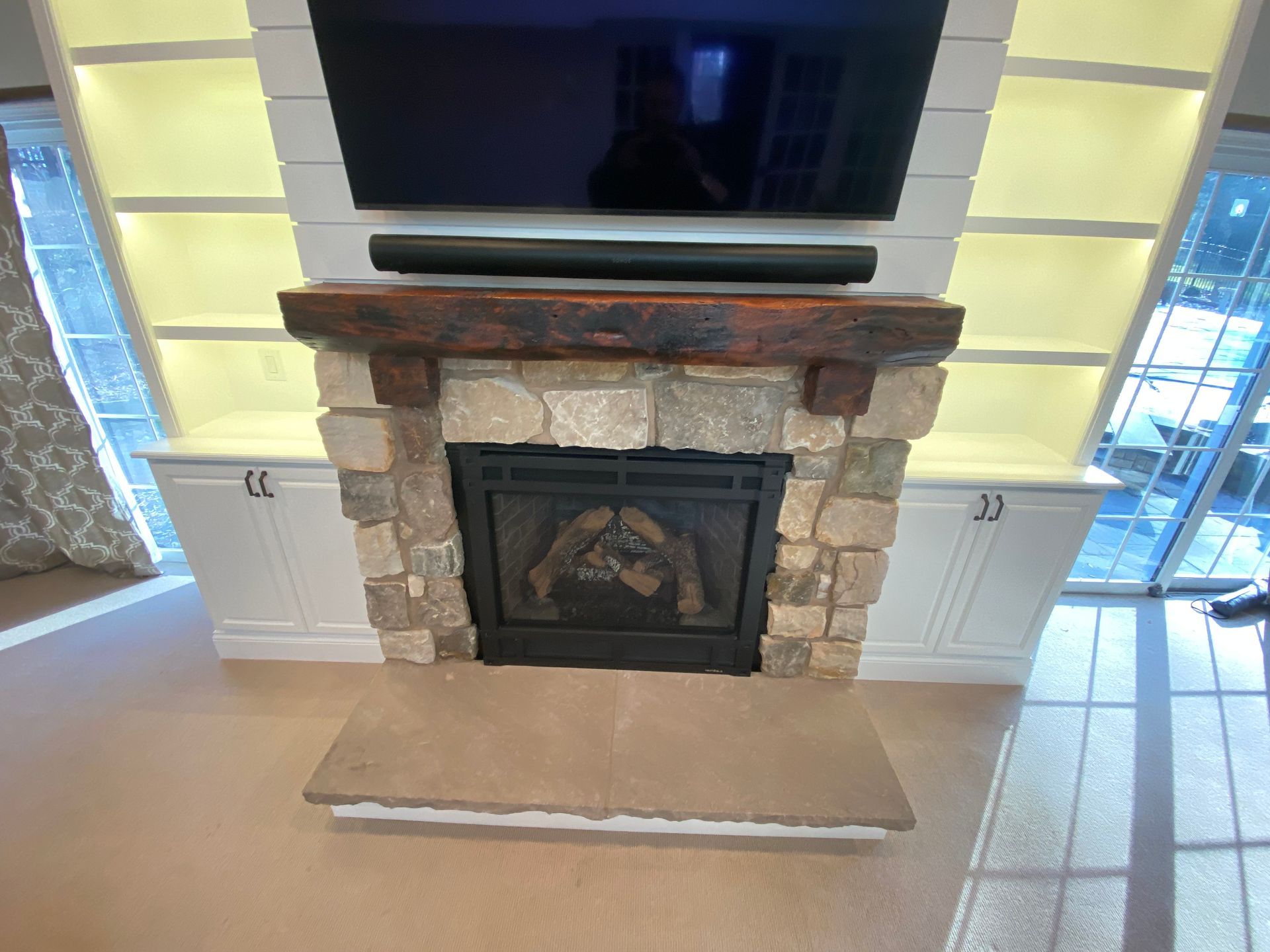 A living room with a fireplace and a flat screen tv above it.