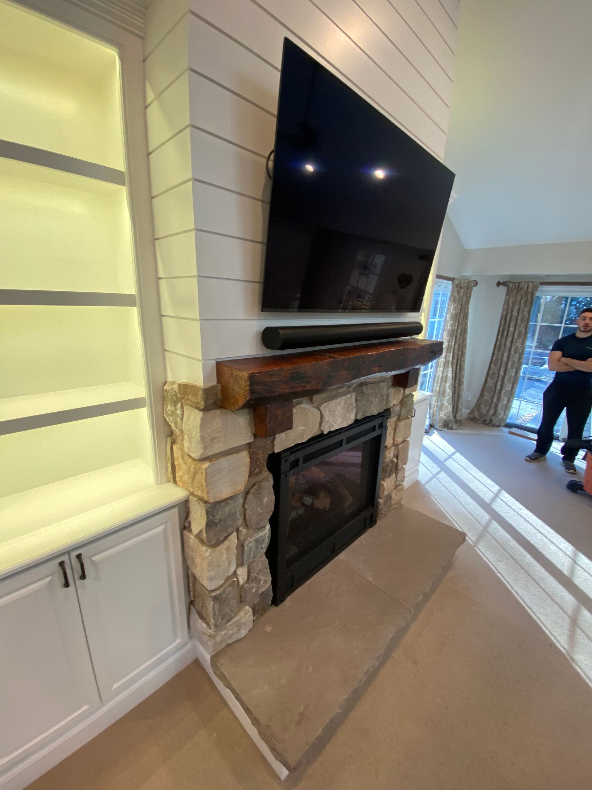 A living room with a fireplace and a flat screen tv