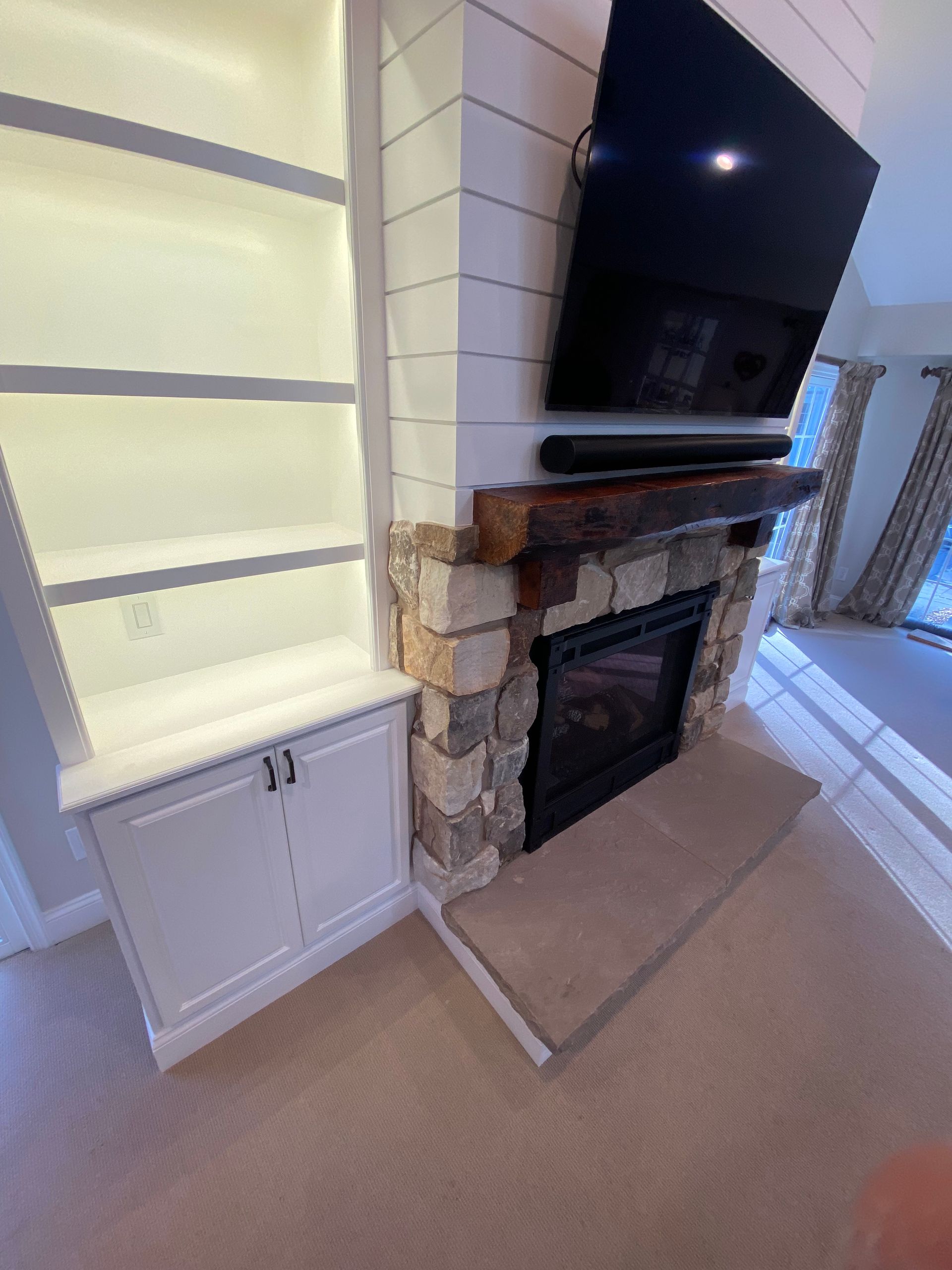 A living room with a fireplace and a flat screen tv.
