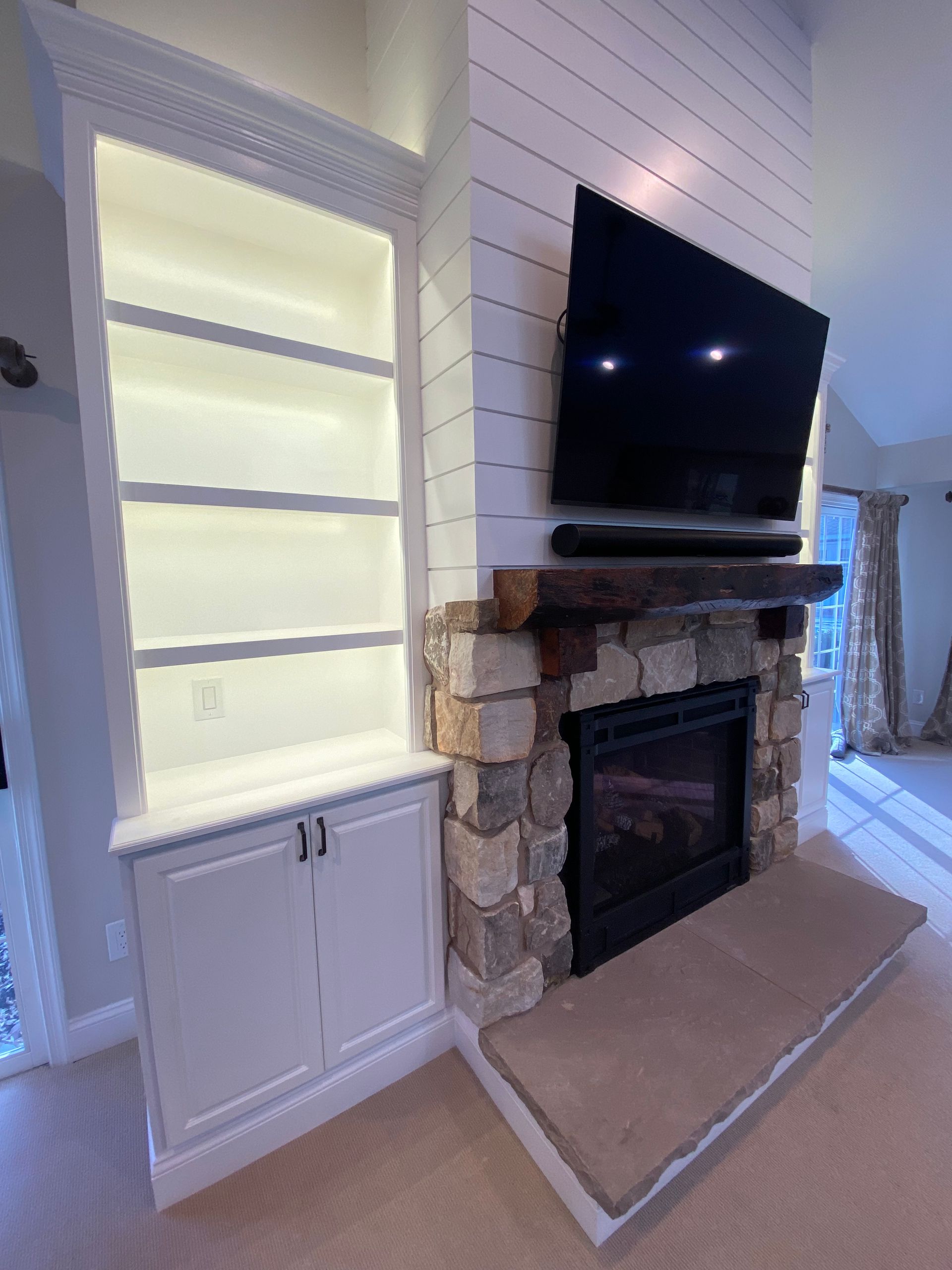 A living room with a fireplace and a flat screen tv