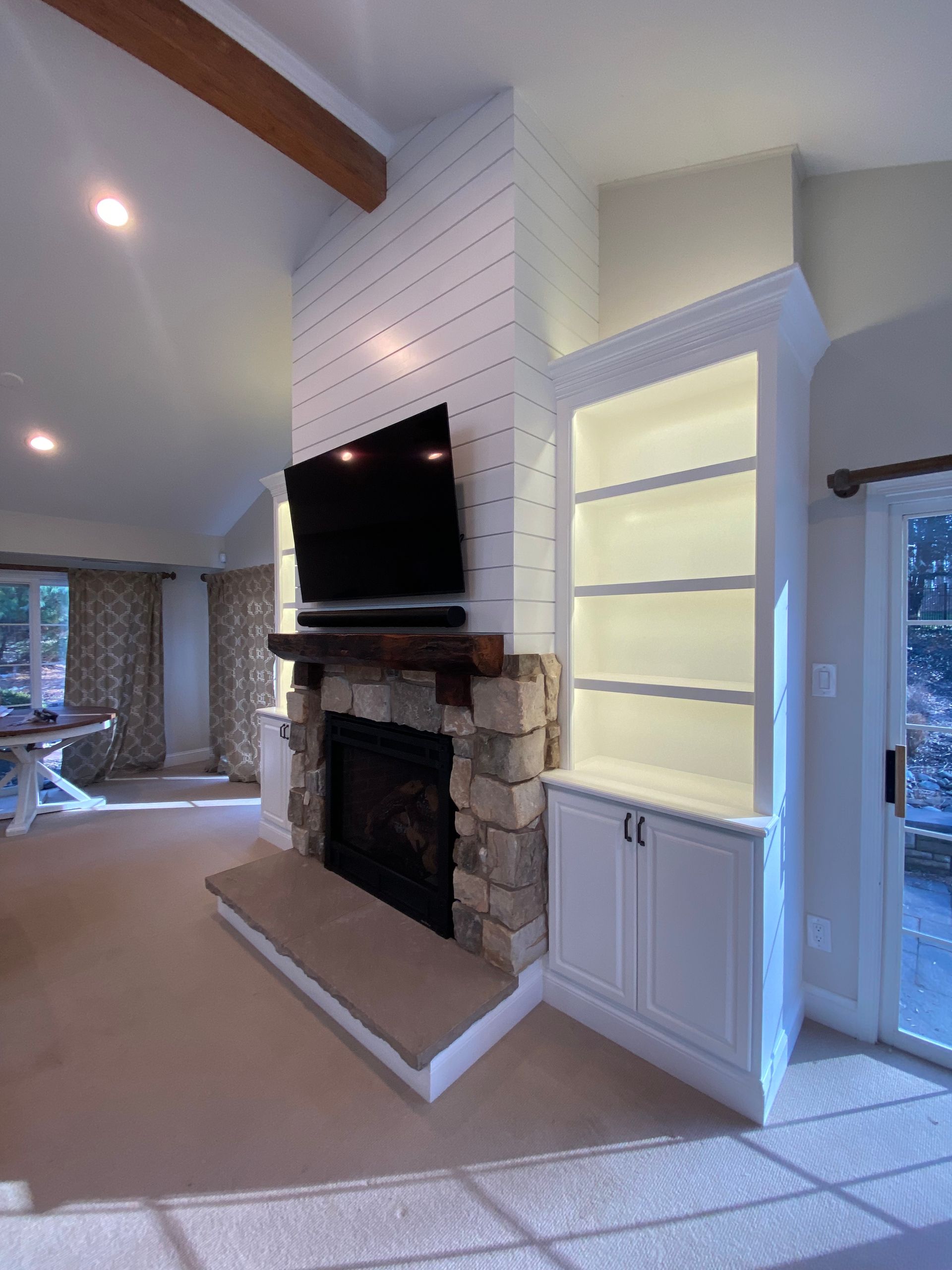 A living room with a fireplace and a flat screen tv
