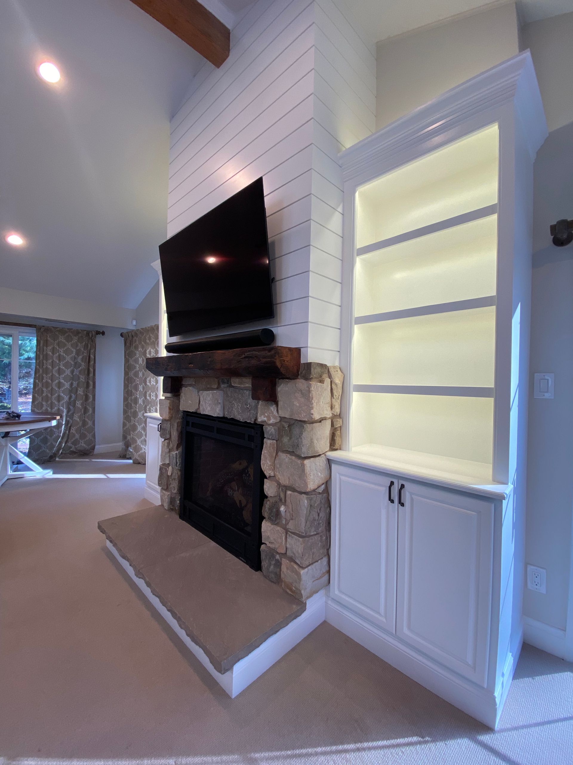 A living room with a fireplace and a flat screen tv