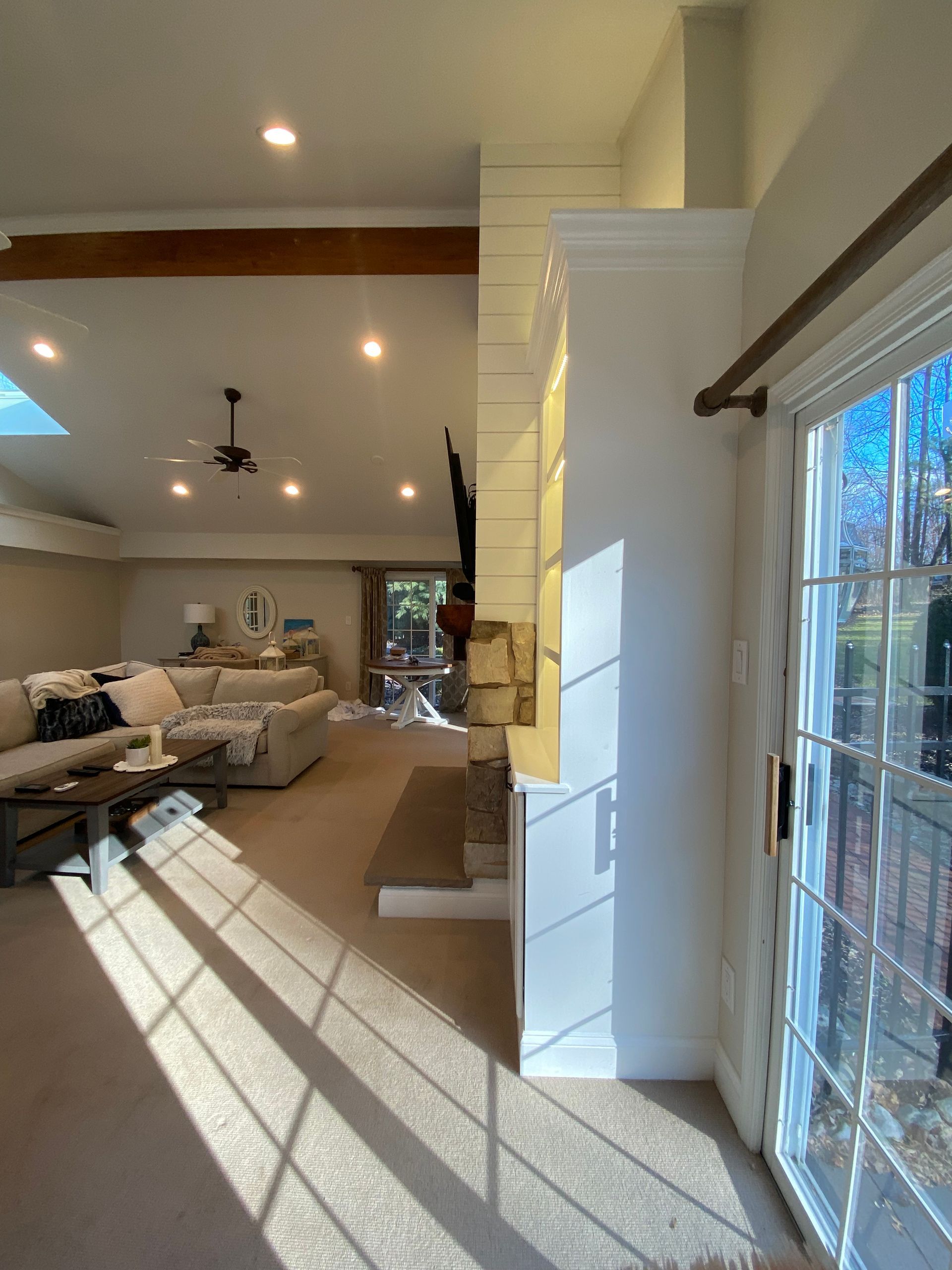 A living room with a sliding glass door and a ceiling fan