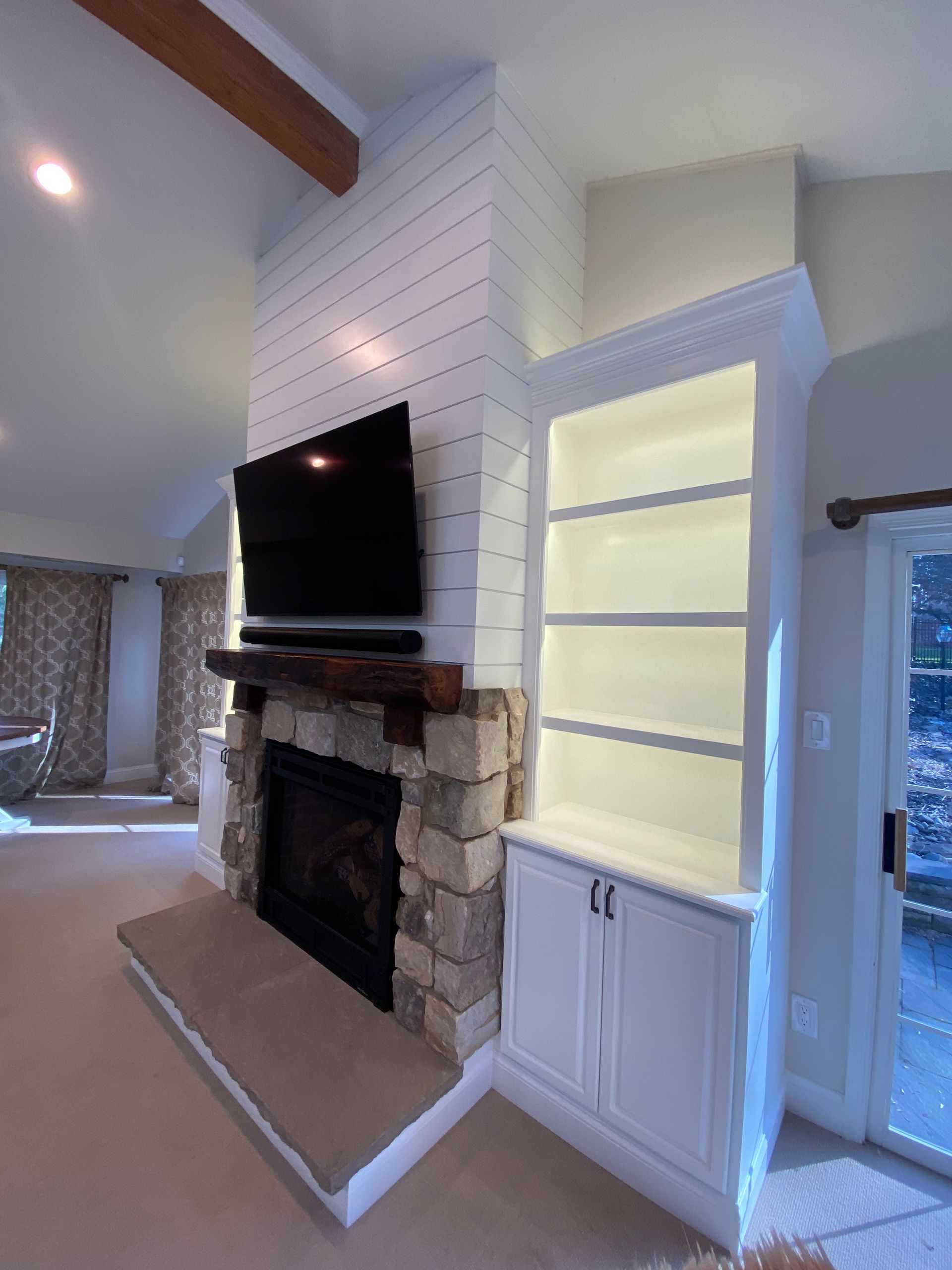 A living room with a fireplace and a flat screen tv