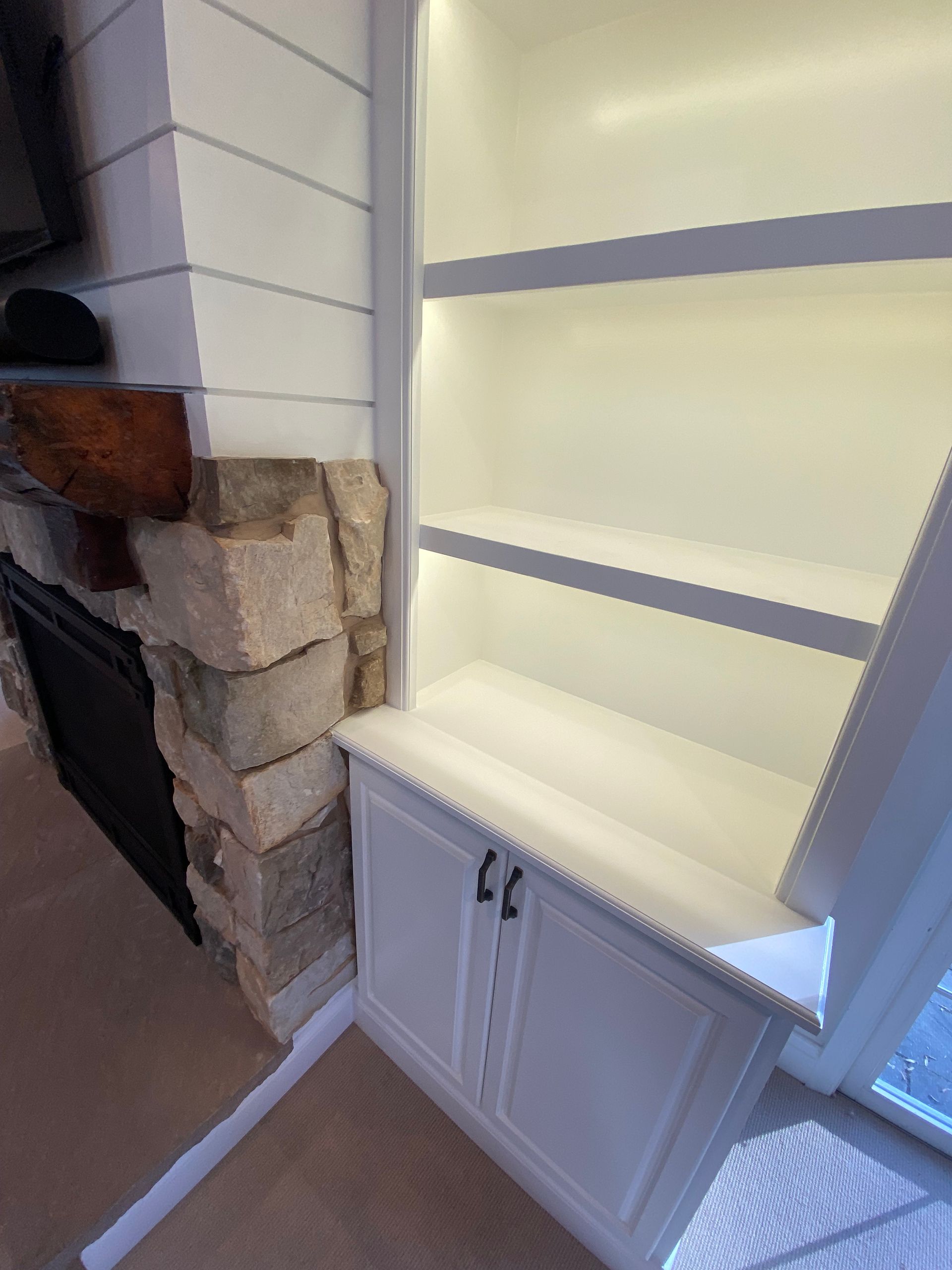 A living room with a fireplace and a bookshelf