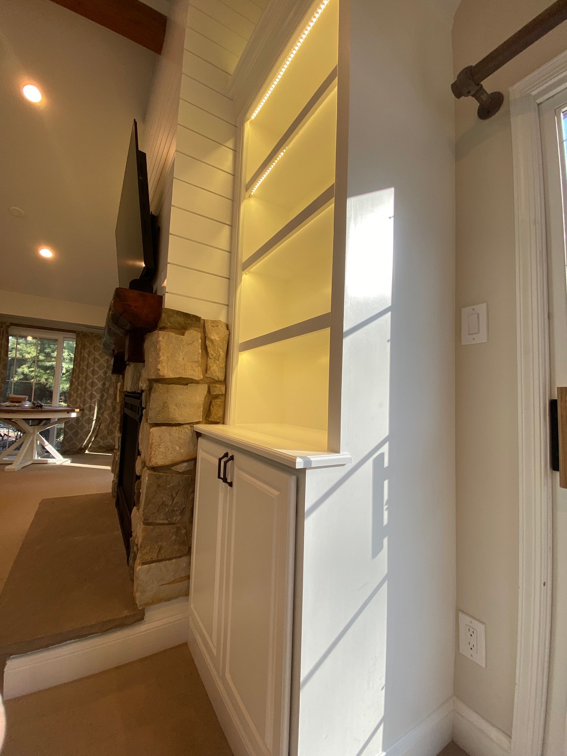 A corner of a room with white cabinets and shelves