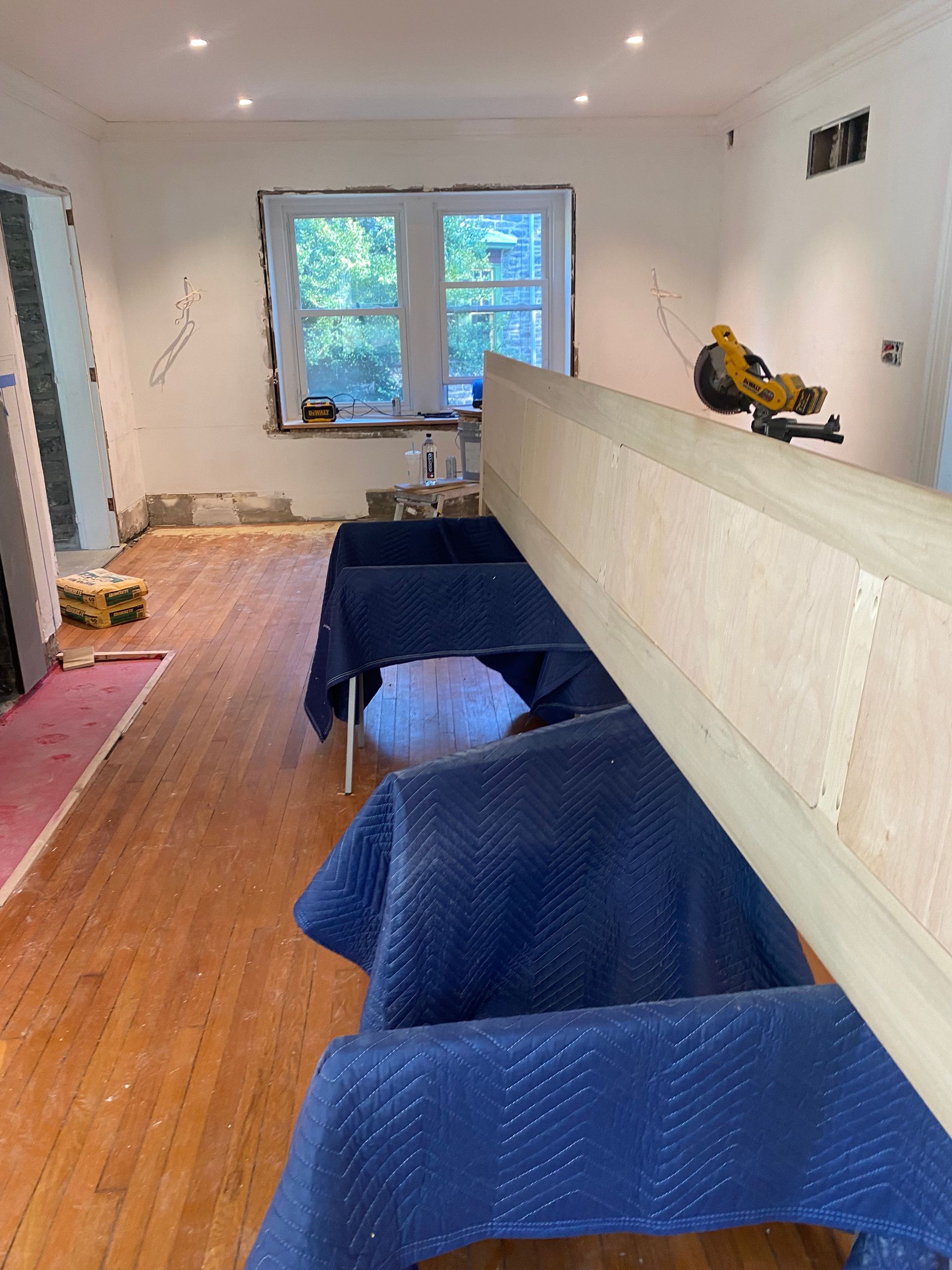 A room with wooden floors and blue blankets on the floor