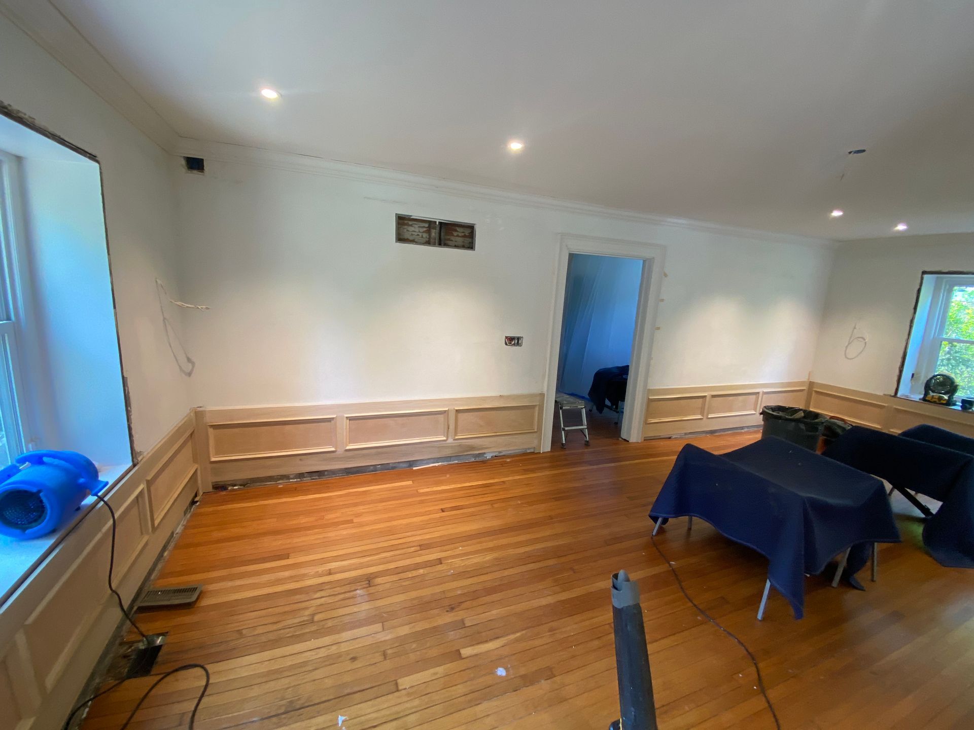 A living room with hardwood floors and white walls.