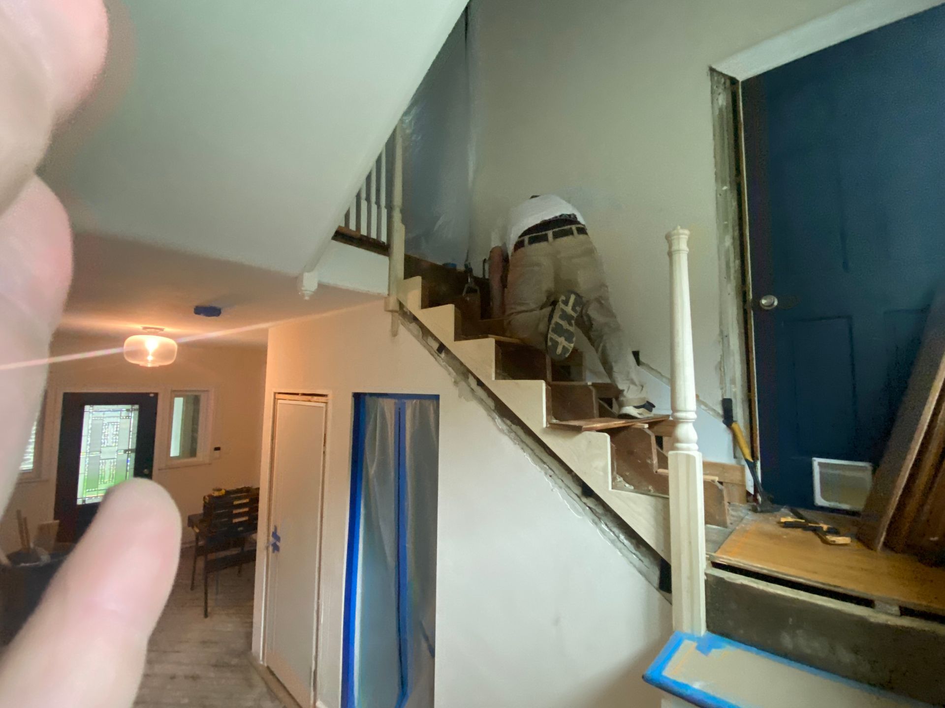 A man is painting the stairs in a house