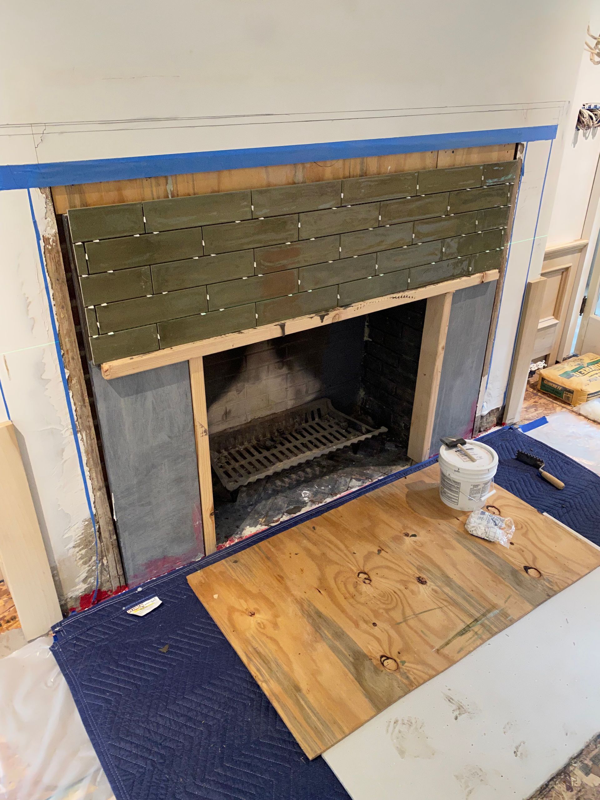A fireplace is being remodeled in a living room.