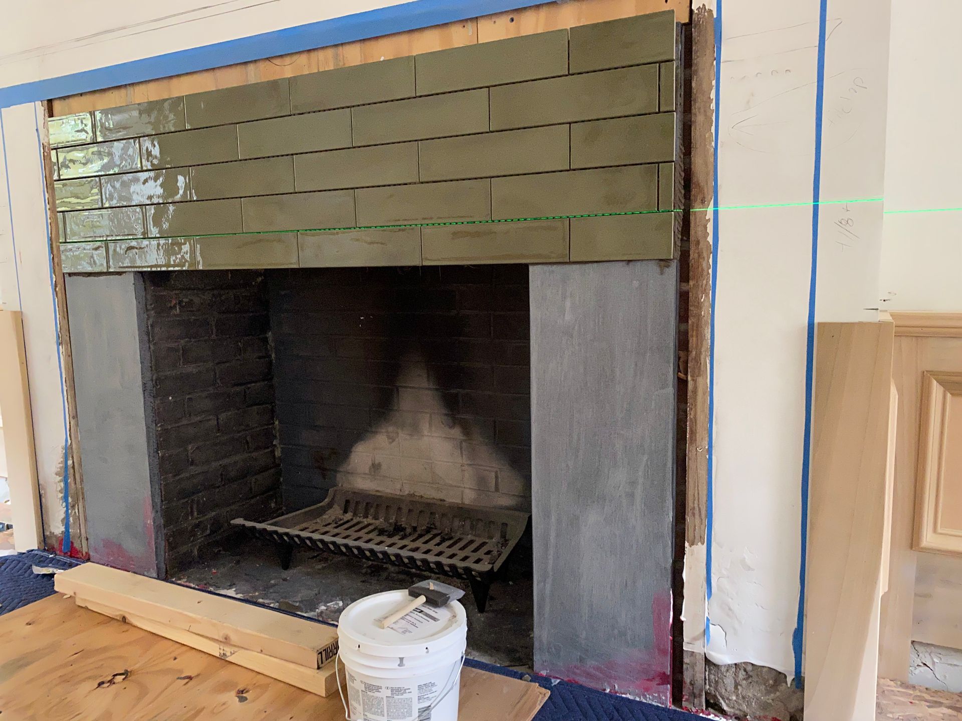 A fireplace is being remodeled in a living room.