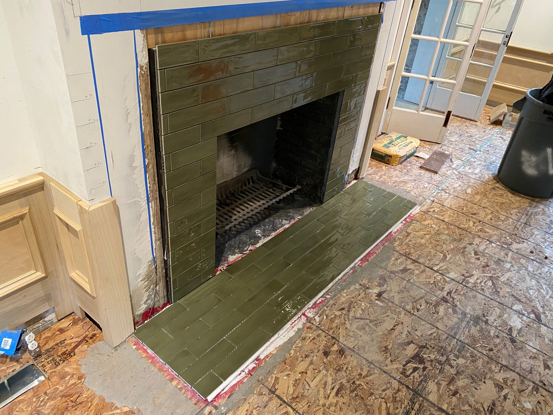 A fireplace is being remodeled in a living room.