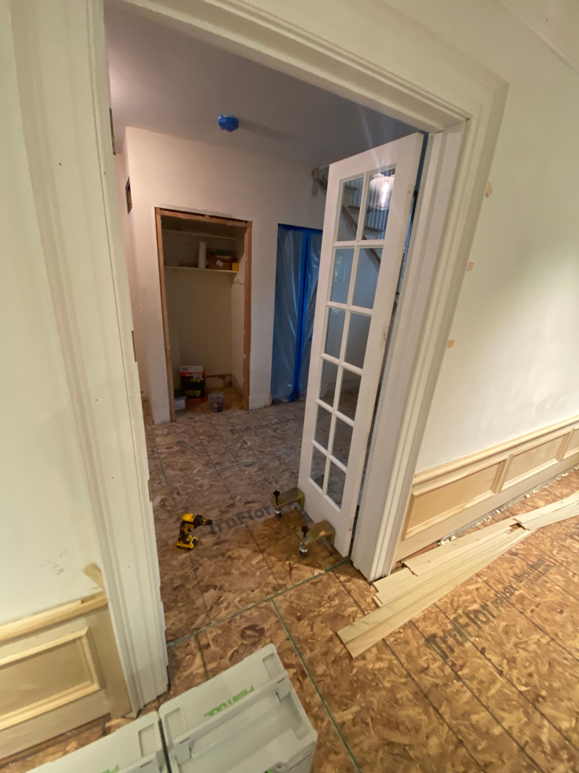 A hallway with a door open and boxes on the floor
