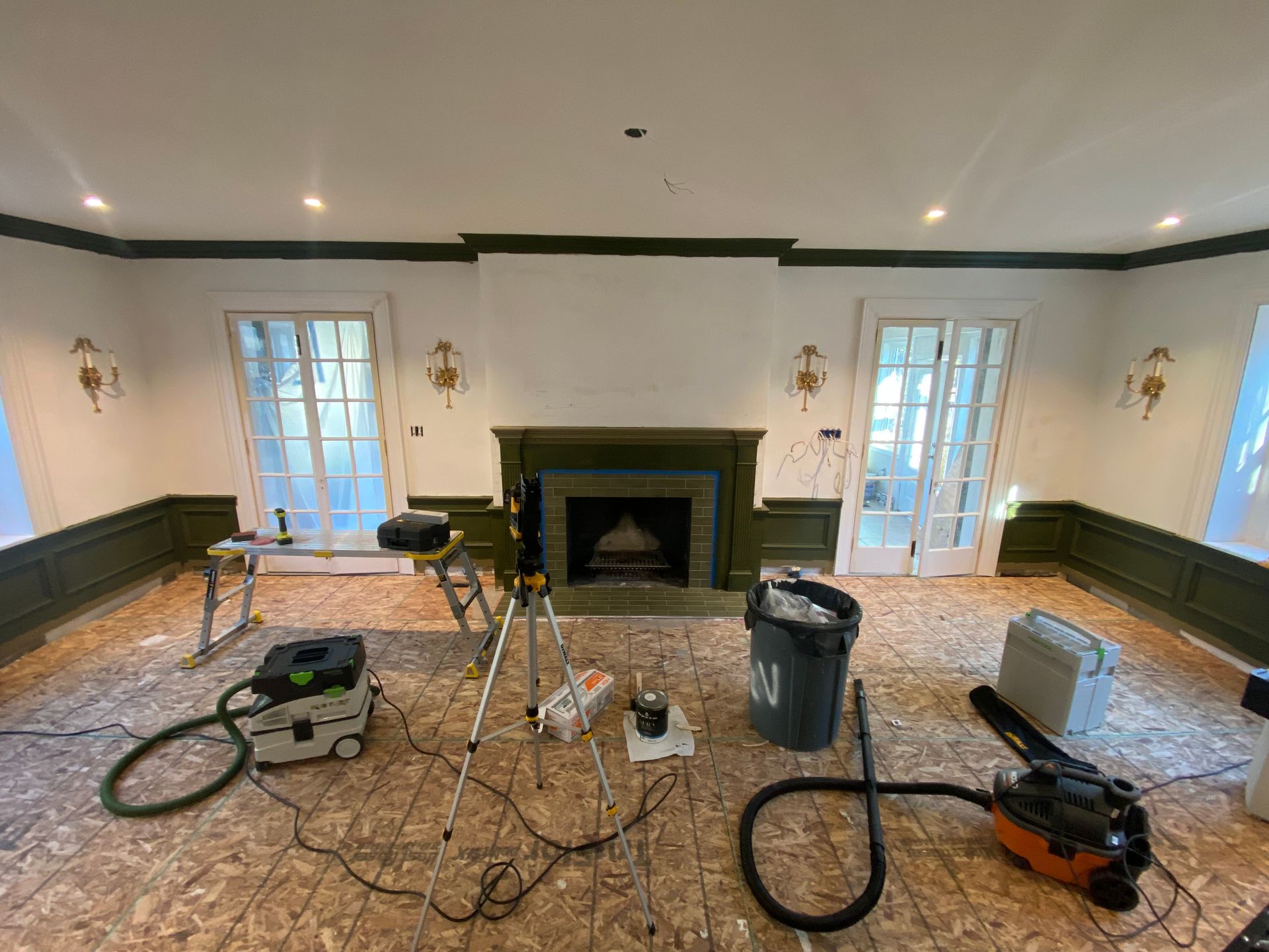 A living room with a fireplace and a vacuum cleaner on the floor.