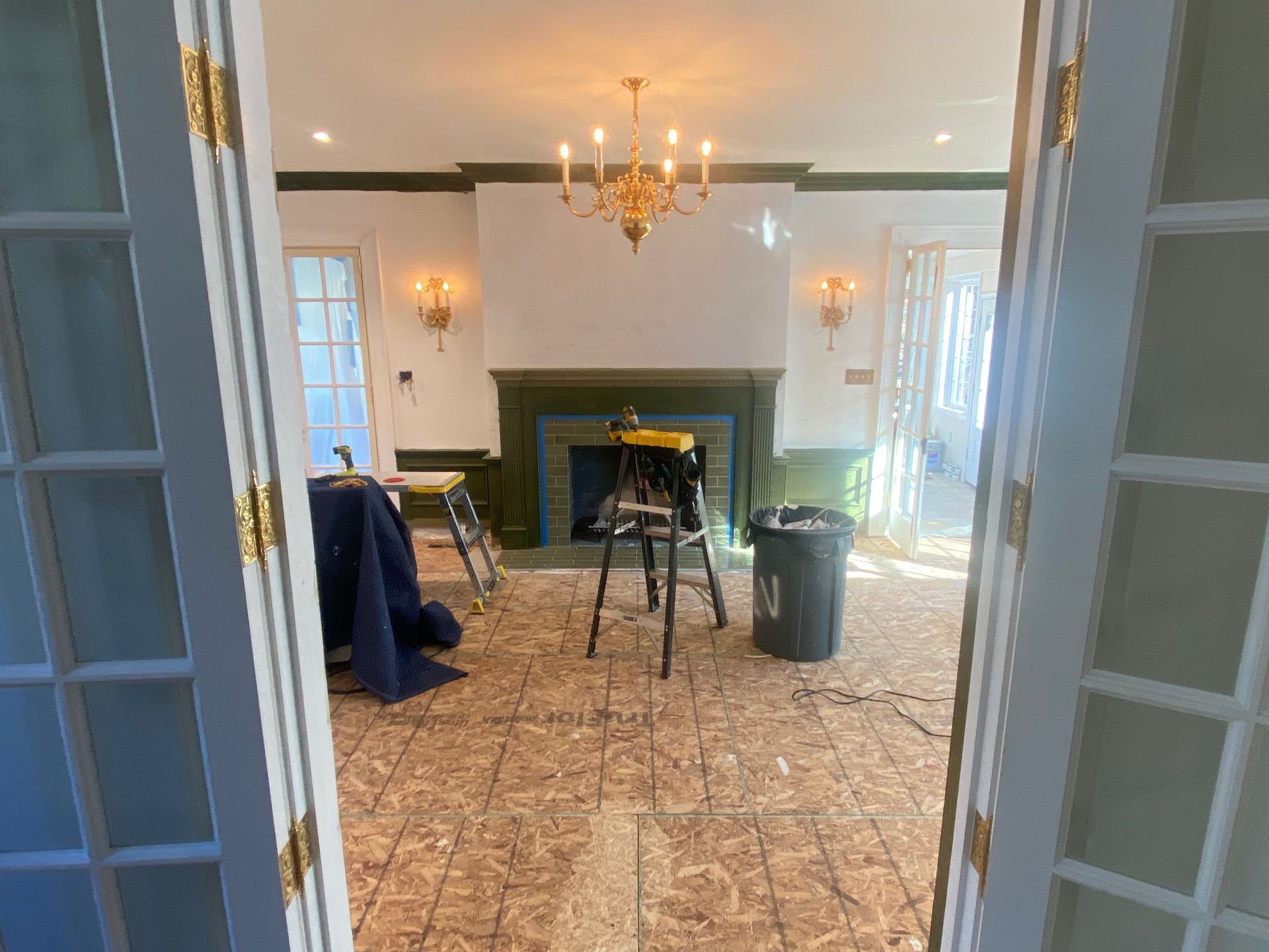 A living room with a fireplace and a ladder in it.