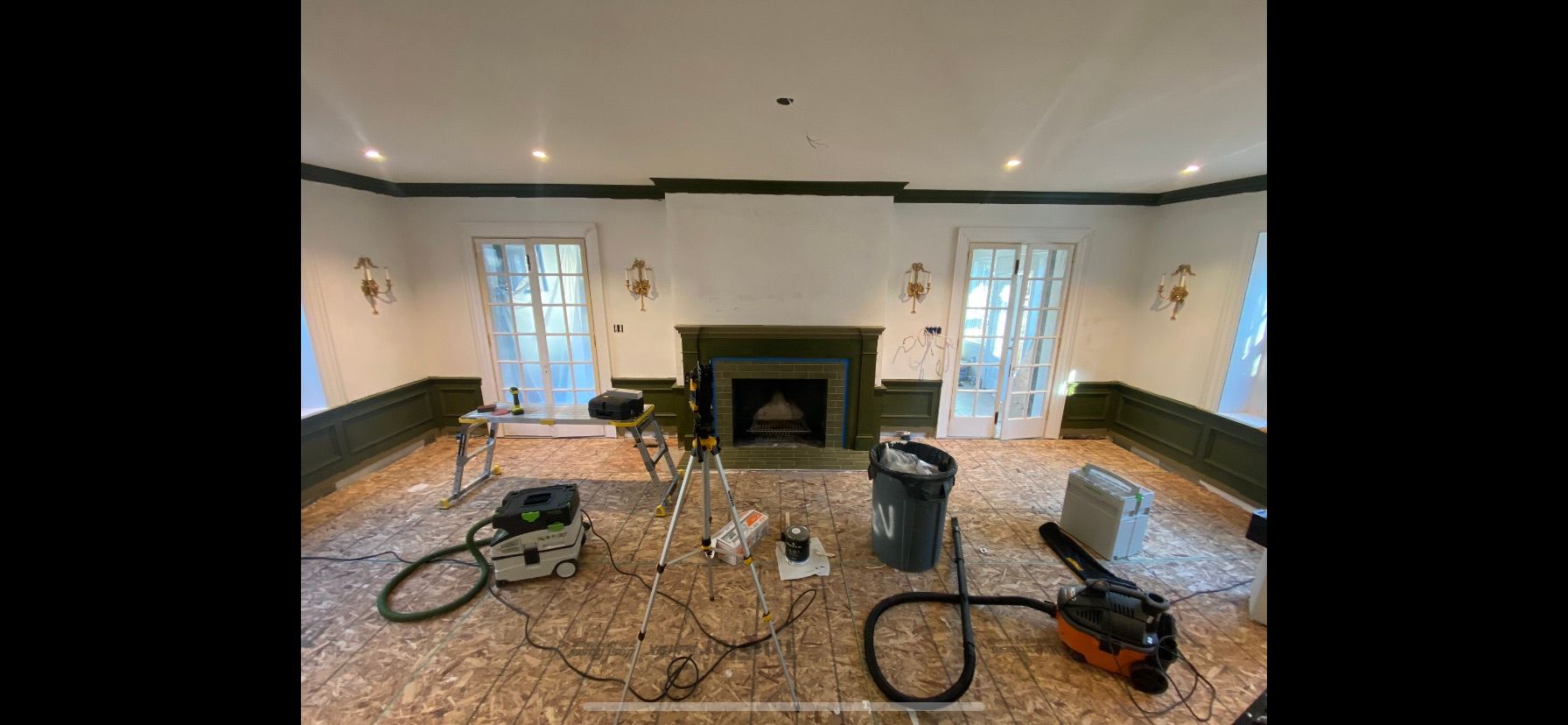 A living room with a fireplace and a vacuum cleaner on the floor.