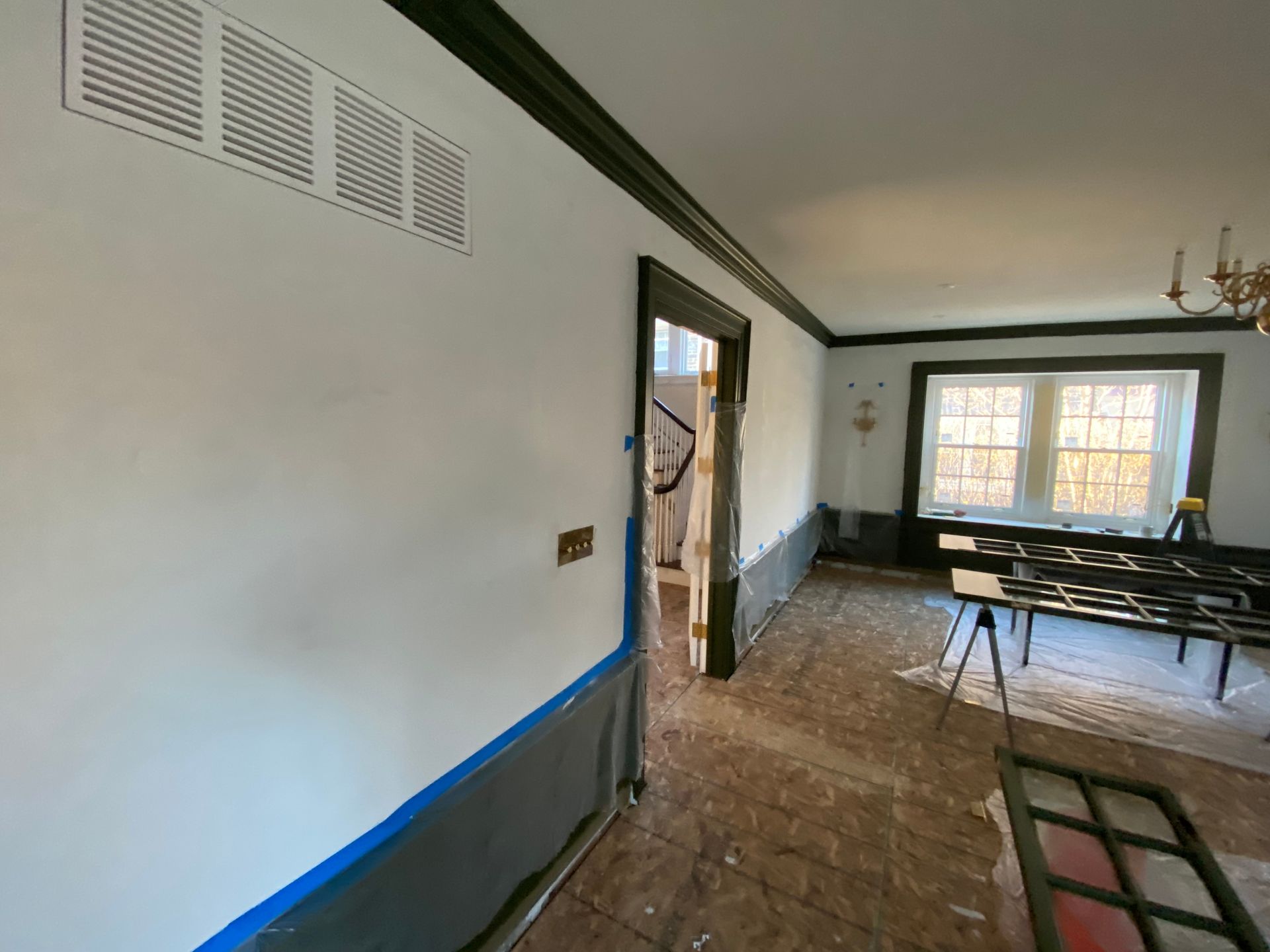 A room with white walls and black trim is being painted