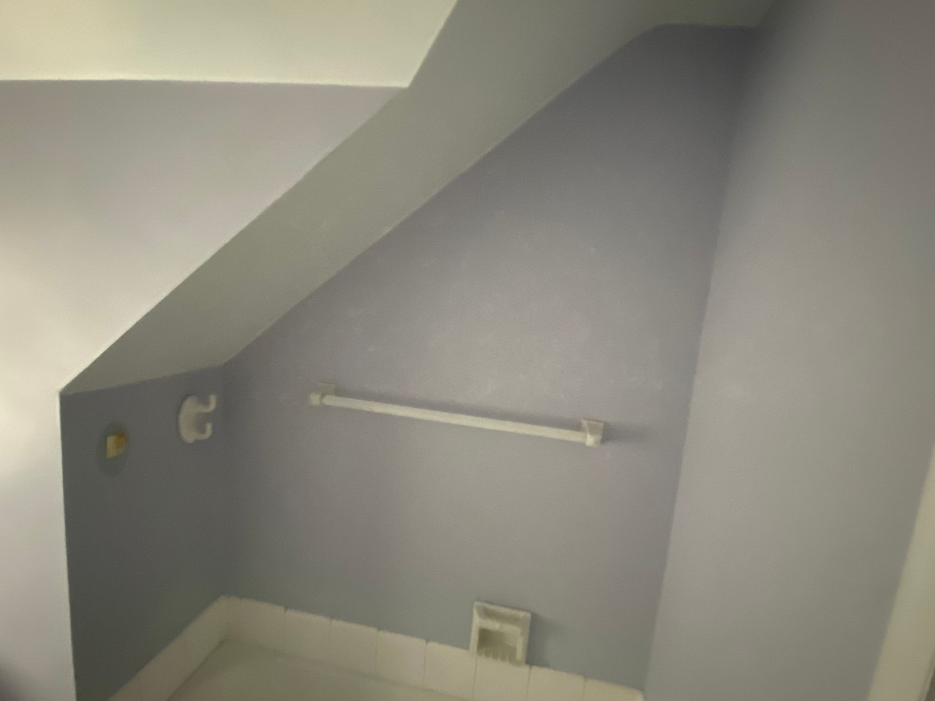 A bathroom with purple walls and a white towel bar.