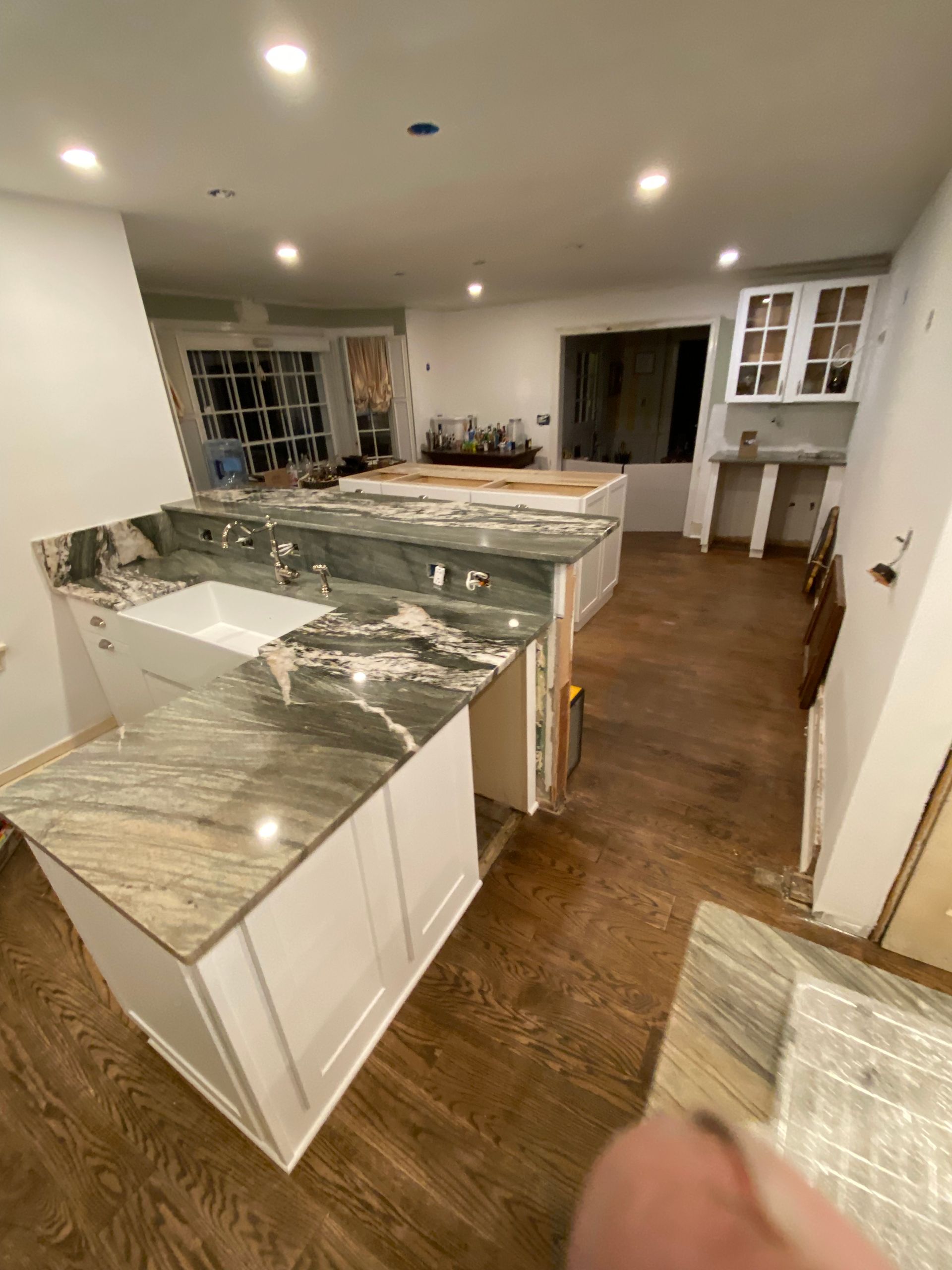 A kitchen with granite counter tops and white cabinets