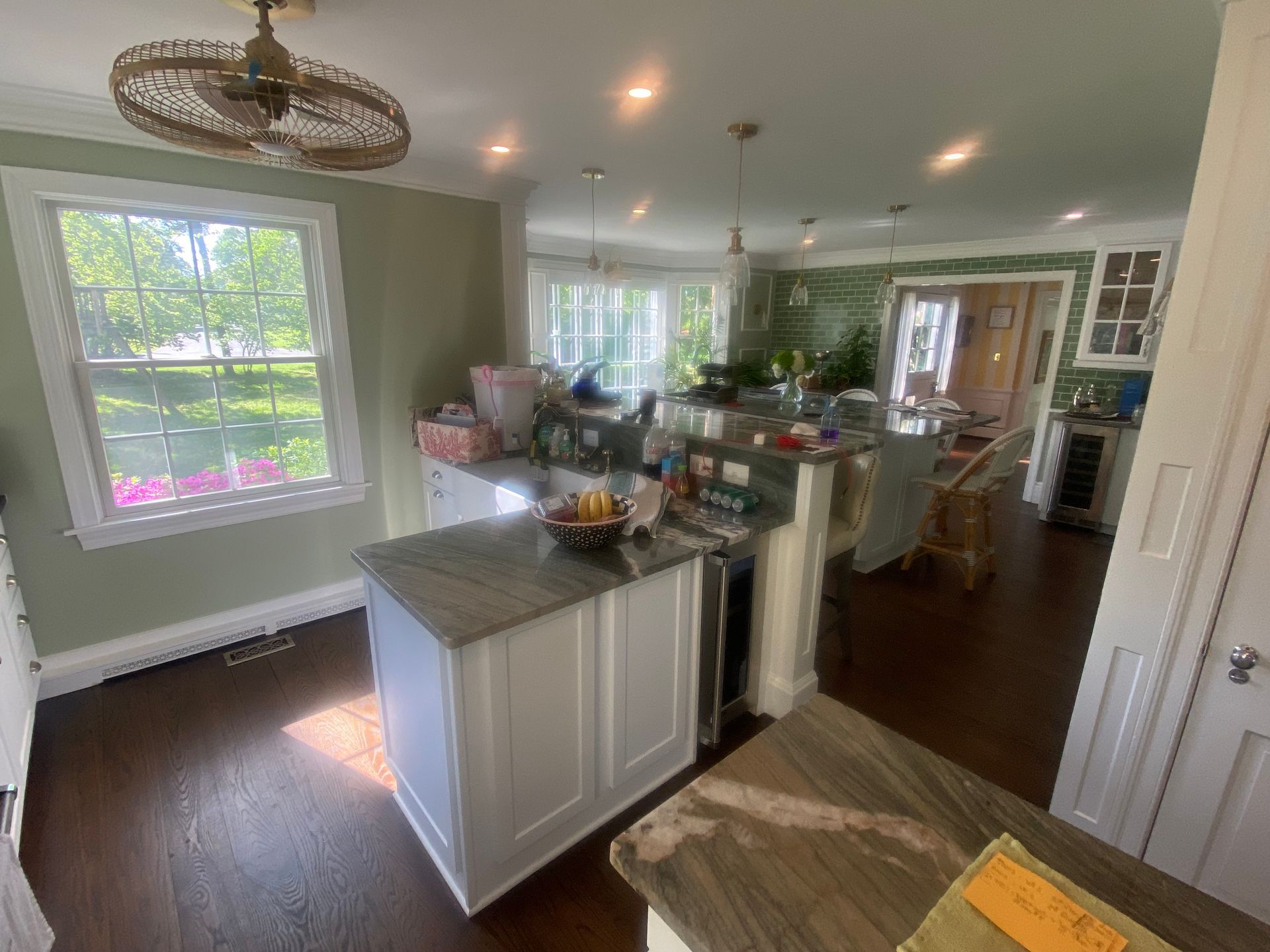 A kitchen with a large island and a ceiling fan.