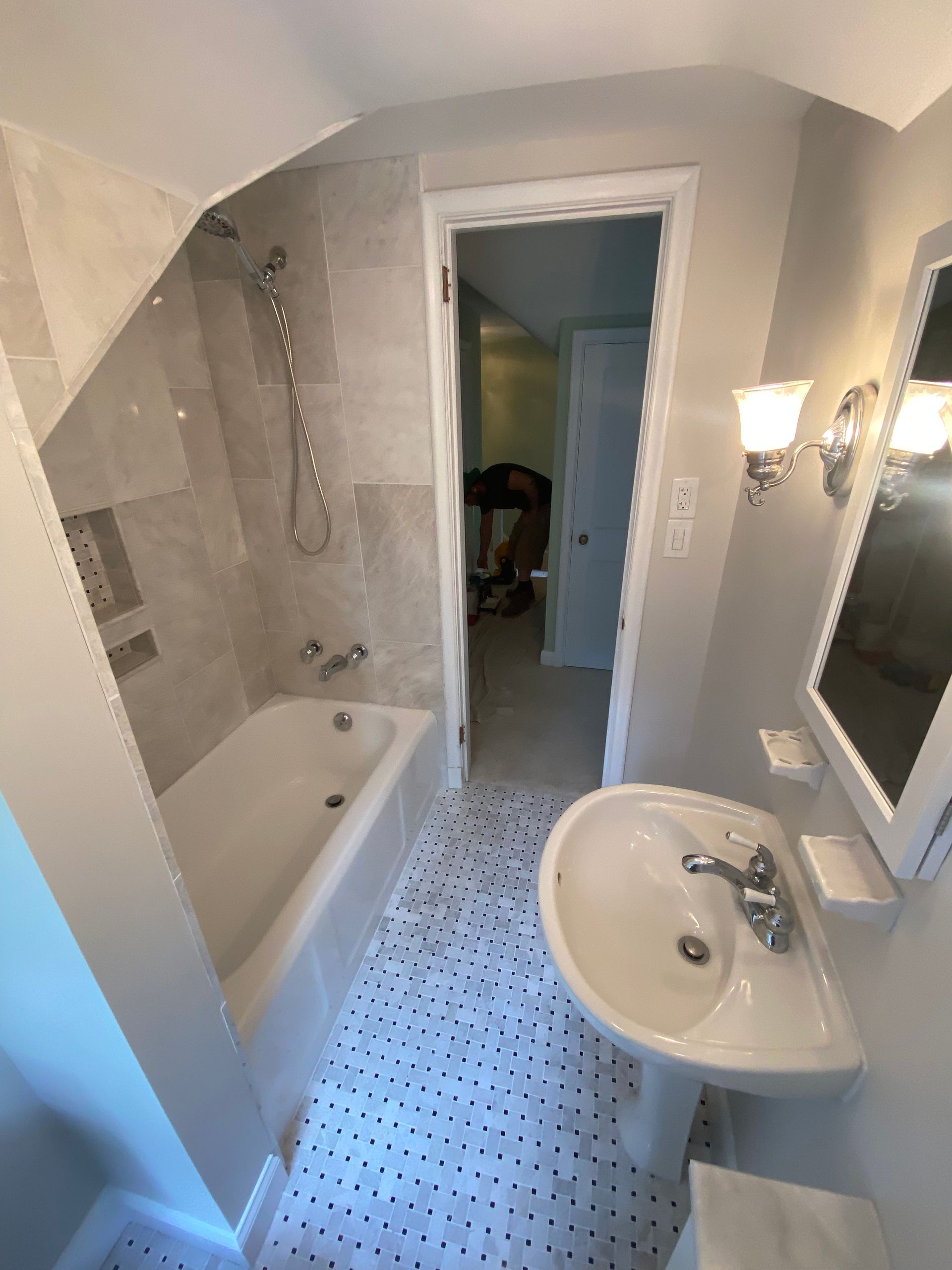 A bathroom with a sink , bathtub and mirror