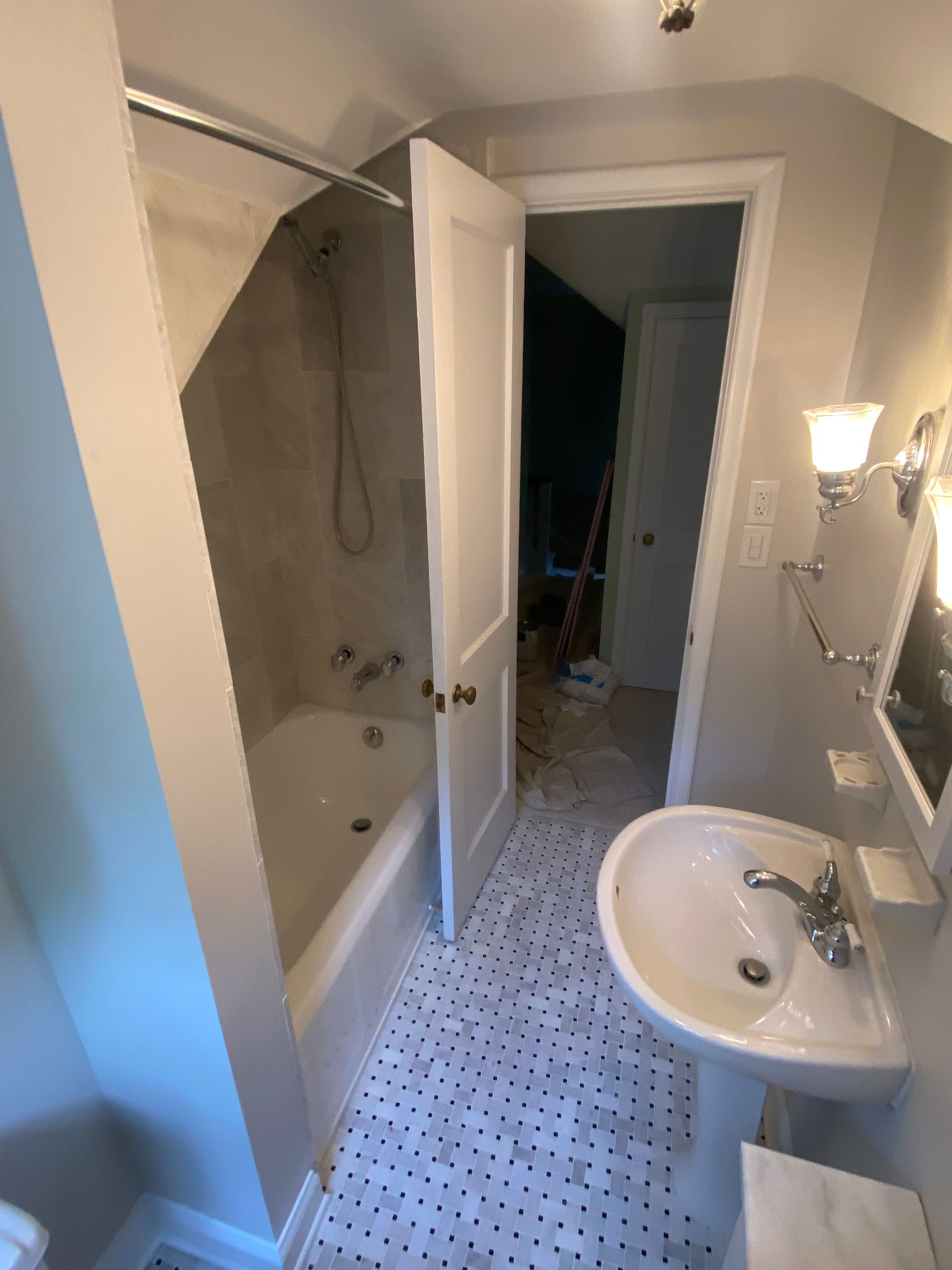 A bathroom with a sink a bathtub and a mirror