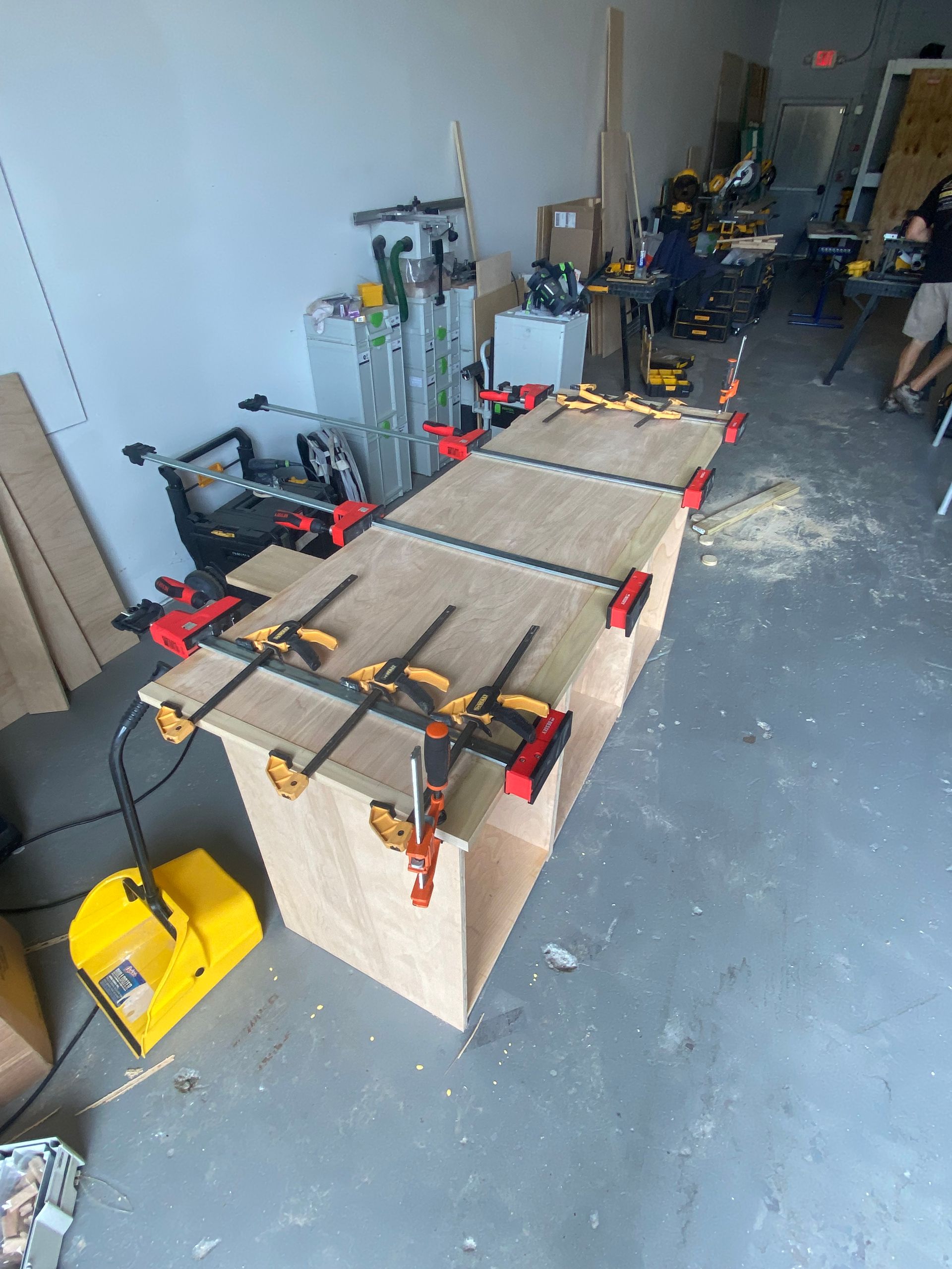 A wooden table with a bunch of clamps on it
